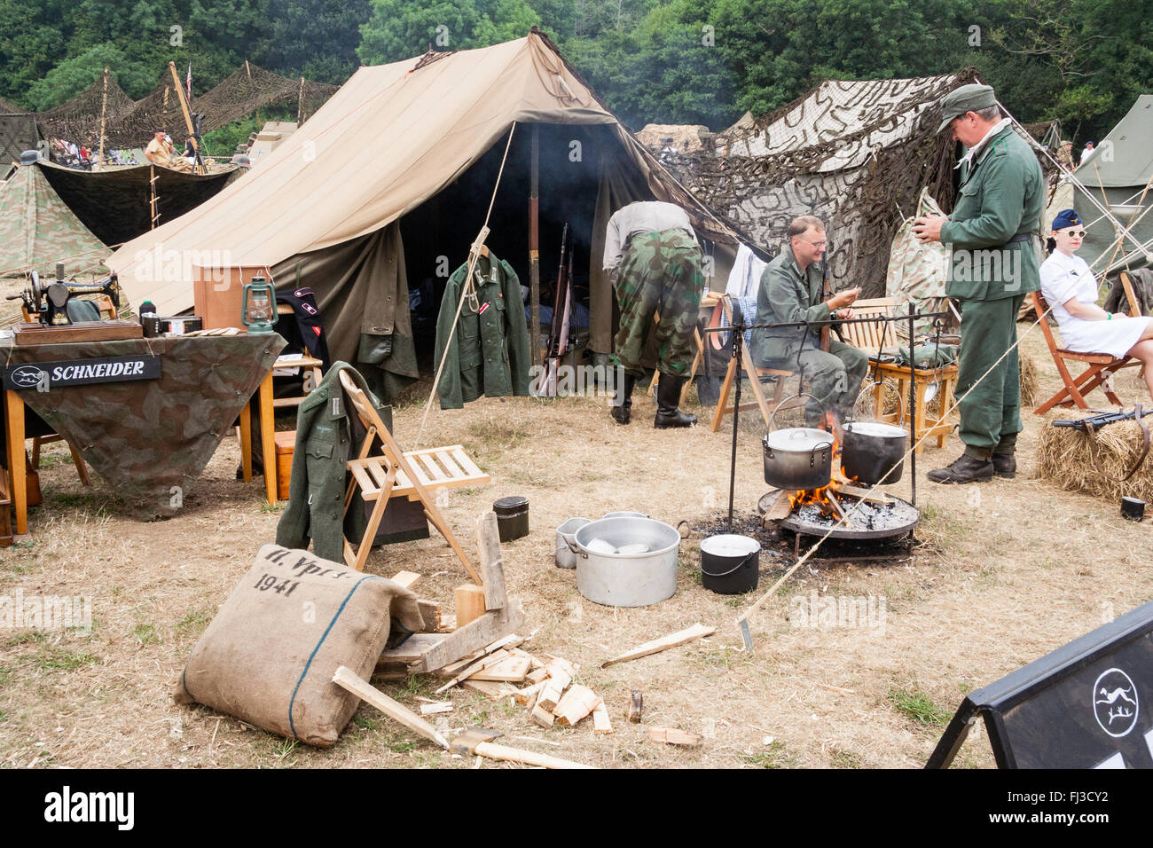 La seconda guerra mondiale la rievocazione. Accampamento tedesco con tende,  cibo per la cottura in pentole sul fuoco, soldati e infermiere. Tipica vita  di camp Foto stock - Alamy