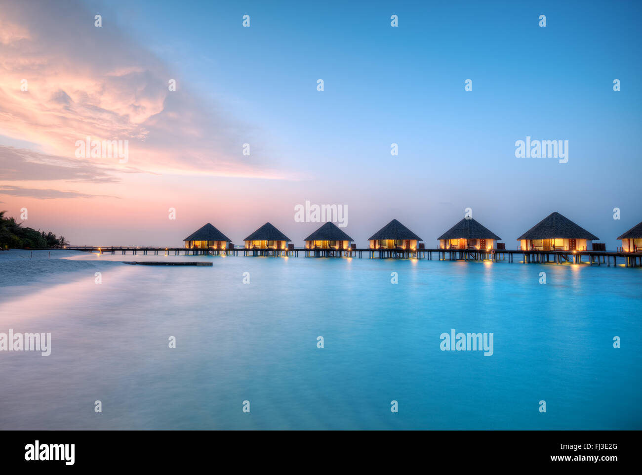 Ville sull'acqua alle Maldive resort Isola in sunset Foto Stock