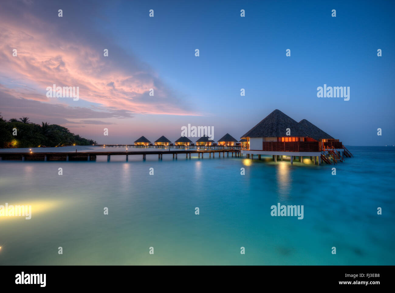 Ville sull'acqua alle Maldive resort Isola in sunset Foto Stock