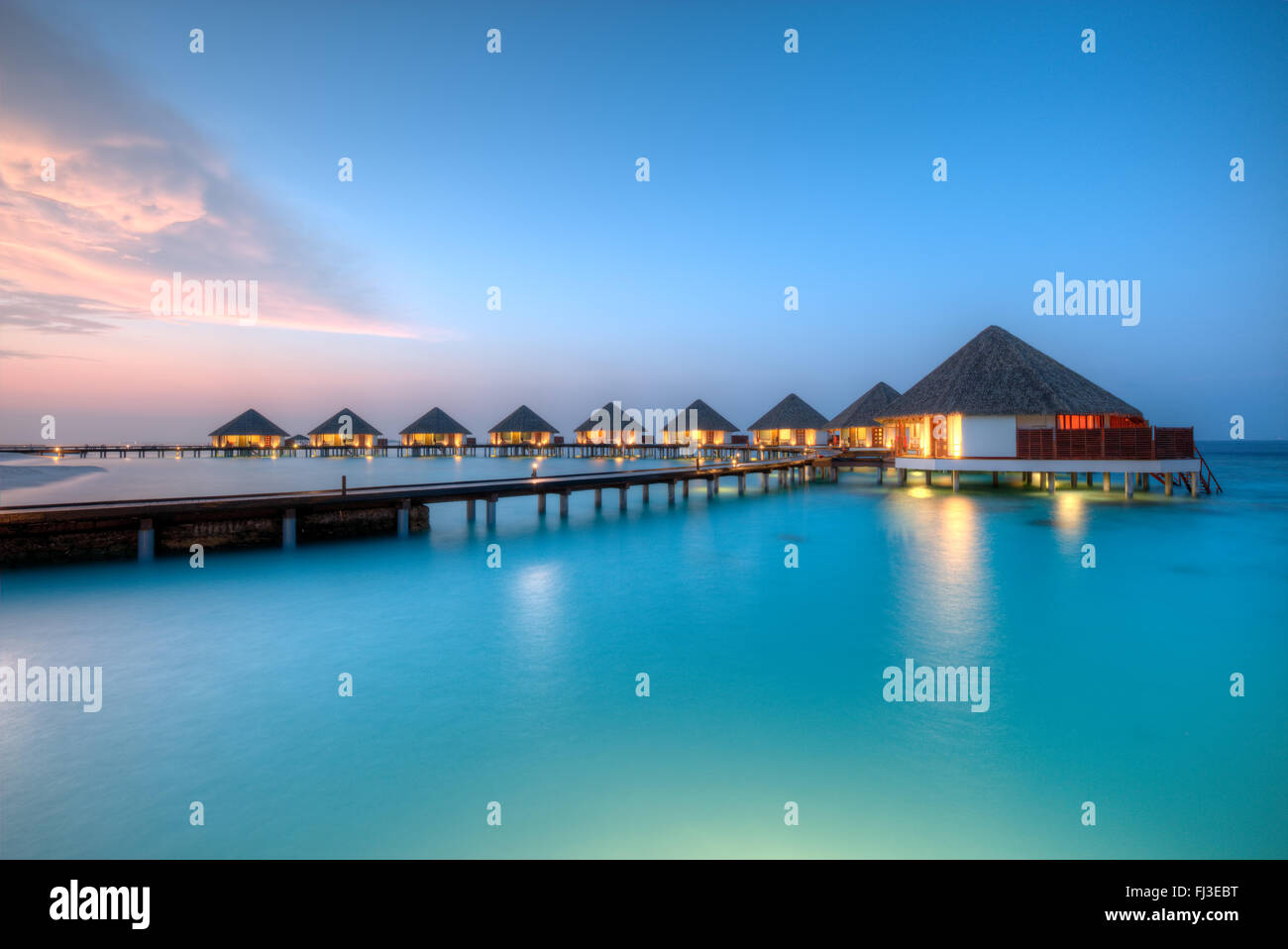 Ville sull'acqua alle Maldive resort Isola in sunset Foto Stock