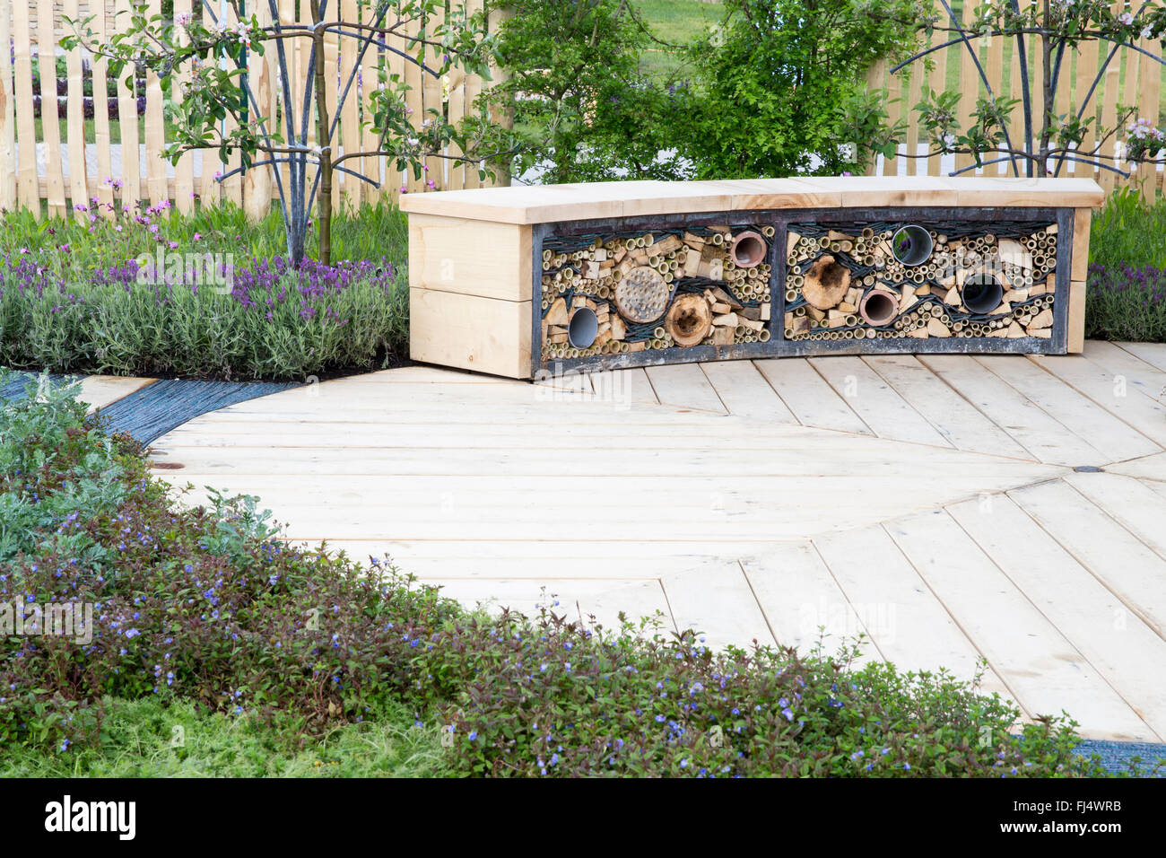 Piccolo giardino adatto alla fauna selvatica con cerchio circolare legno di legno ponte in legno patio e panca con insetto hotel motel Regno Unito Foto Stock