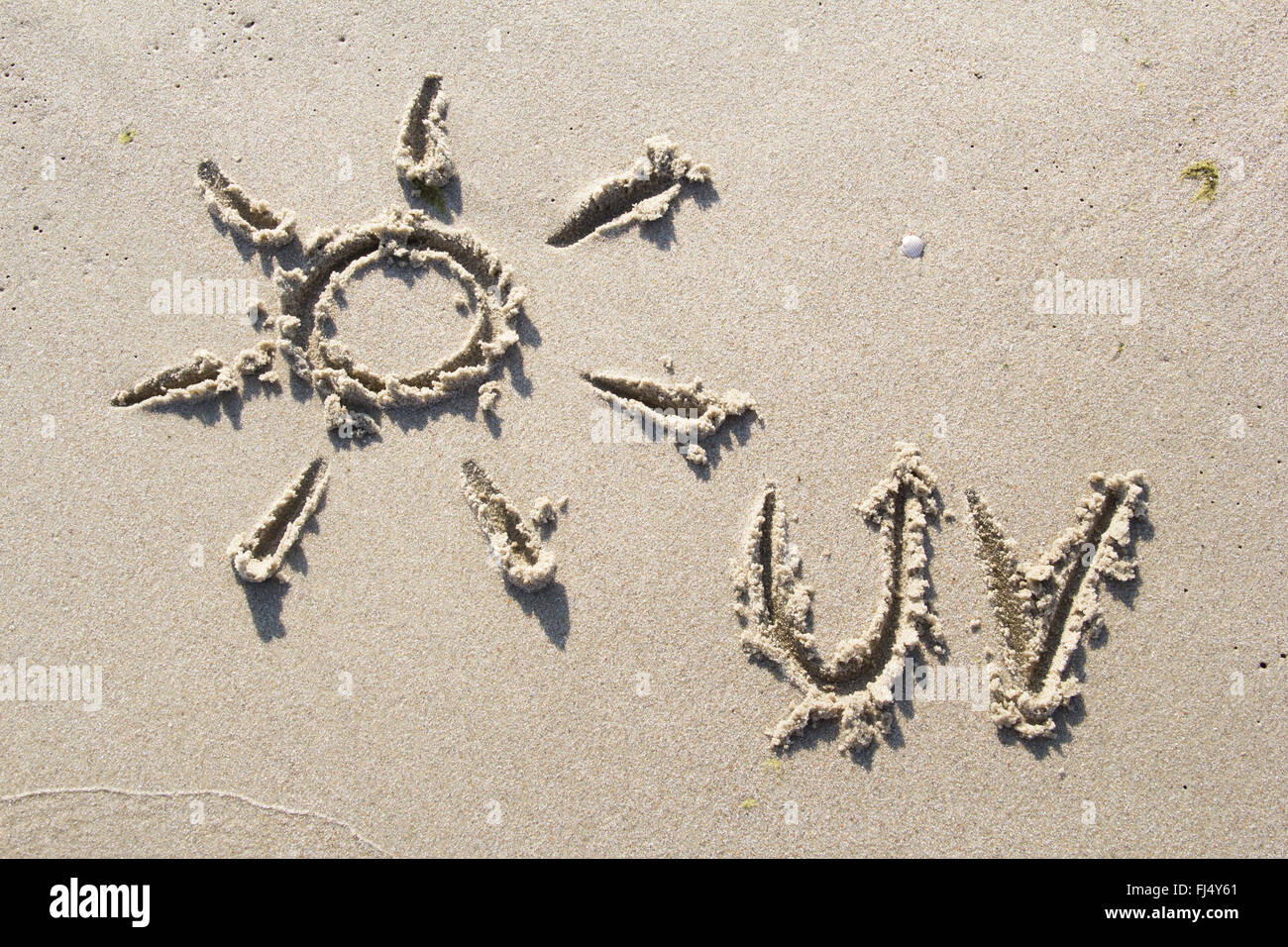 Simbolo del sole disegnato in sabbia Foto Stock