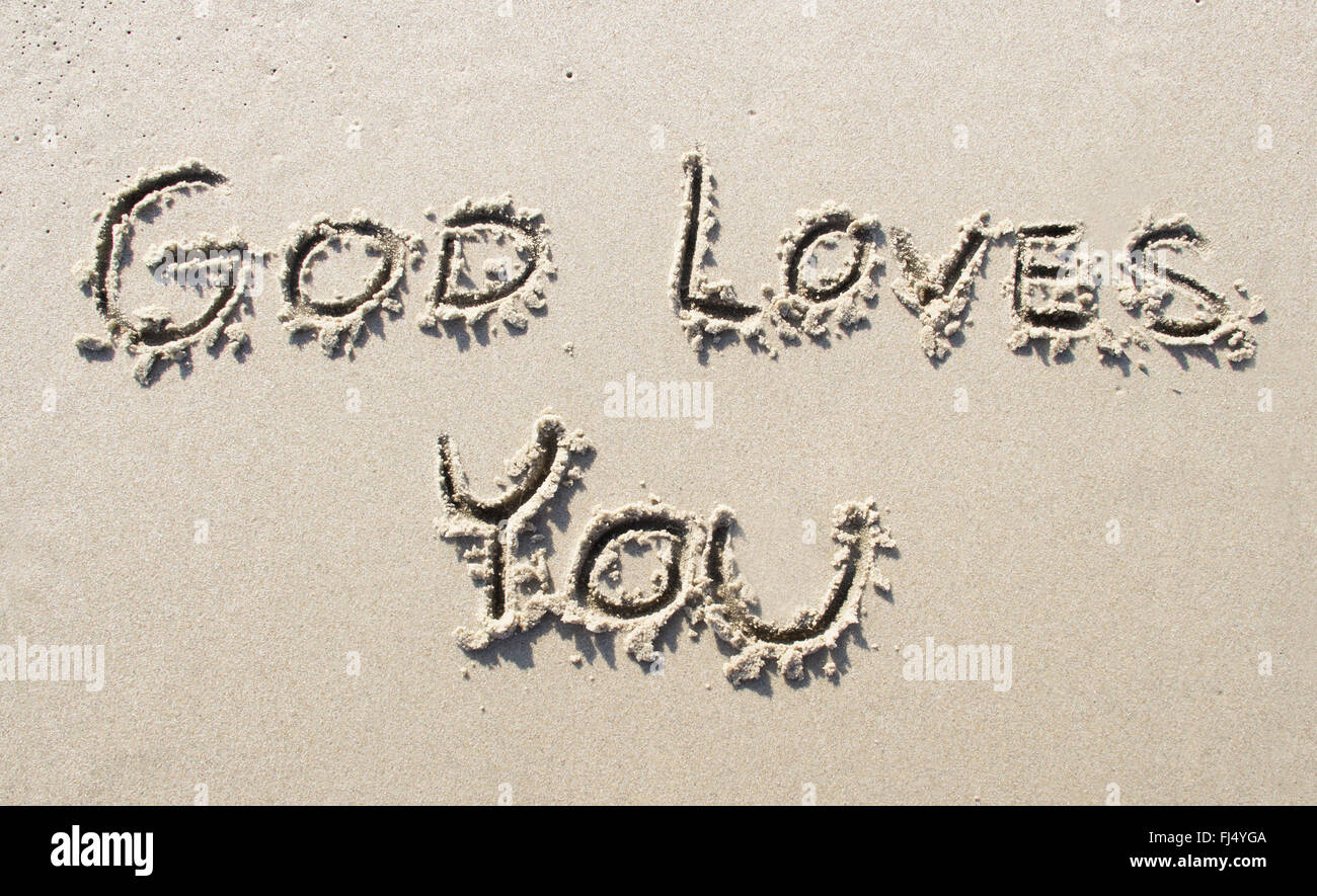 "Dio ti ama' writtwen sulla spiaggia di sabbia Foto Stock