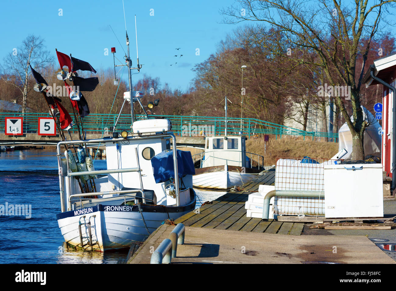 Ronneby, Svezia - 26 Febbraio 2016: piccole barche da pesca ormeggiate nel porto. Il fiume Ronnebyan flusso delicatamente accanto alle barche. Foto Stock