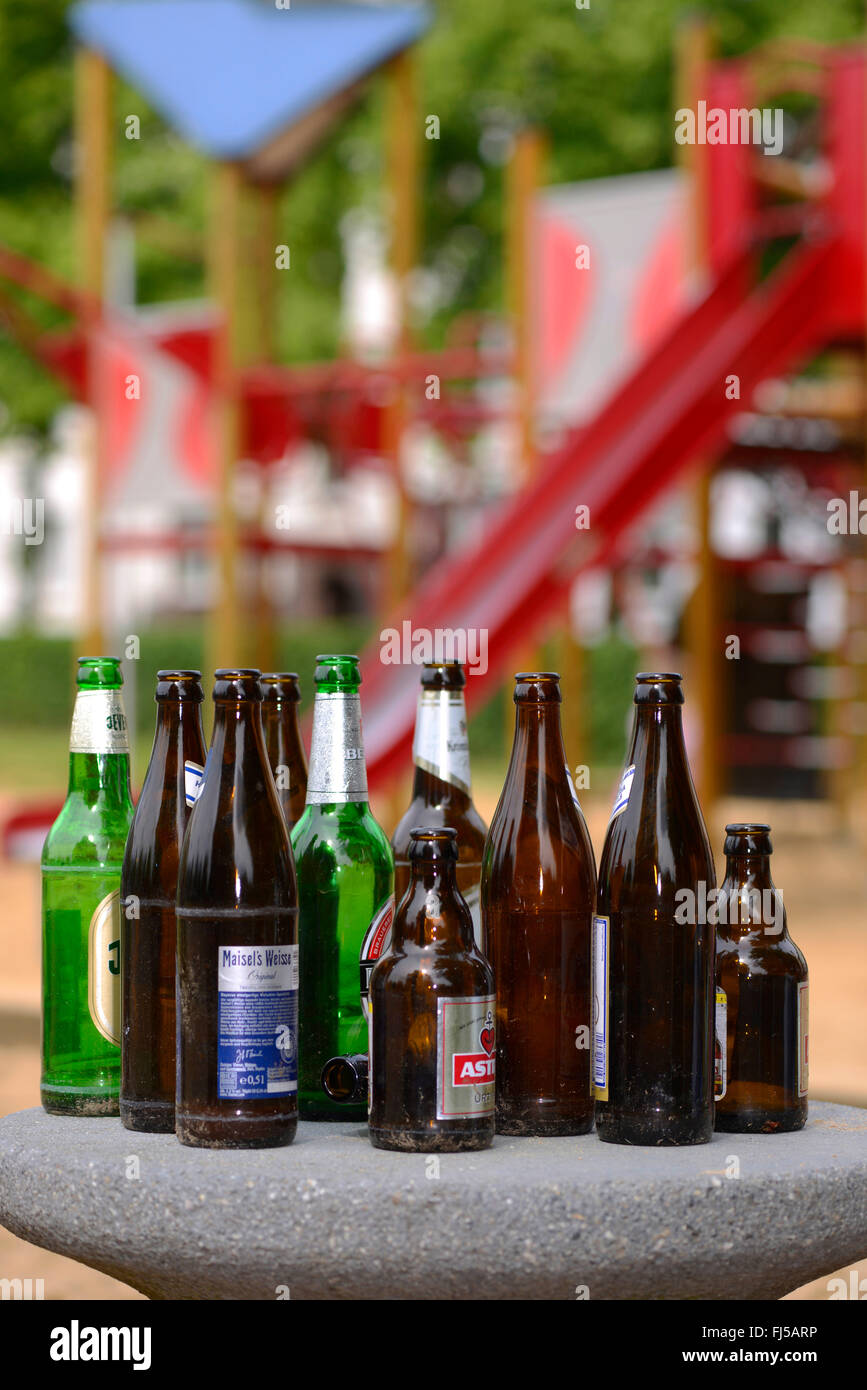 Svuotare le bottiglie di birra in un parco giochi, Germania Foto Stock