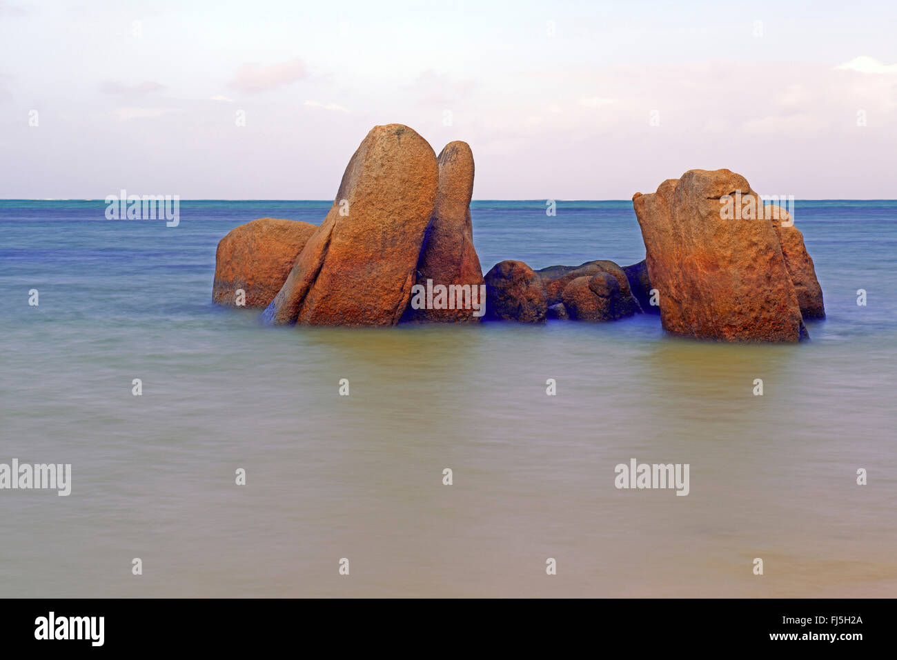 Rocce di granito nell'Oceano Indiano la mattina presto, Seychelles, Praslin, Grand Anse Foto Stock