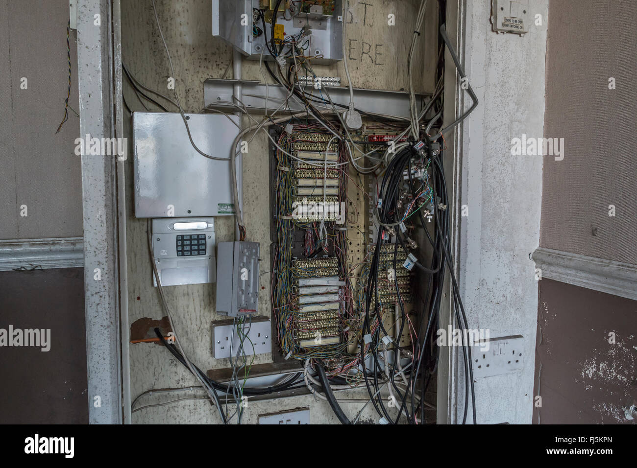 Un telefono scheda di distribuzione in un vecchio blocco ufficio con parti derubato e copertine mancanti, Foto Stock