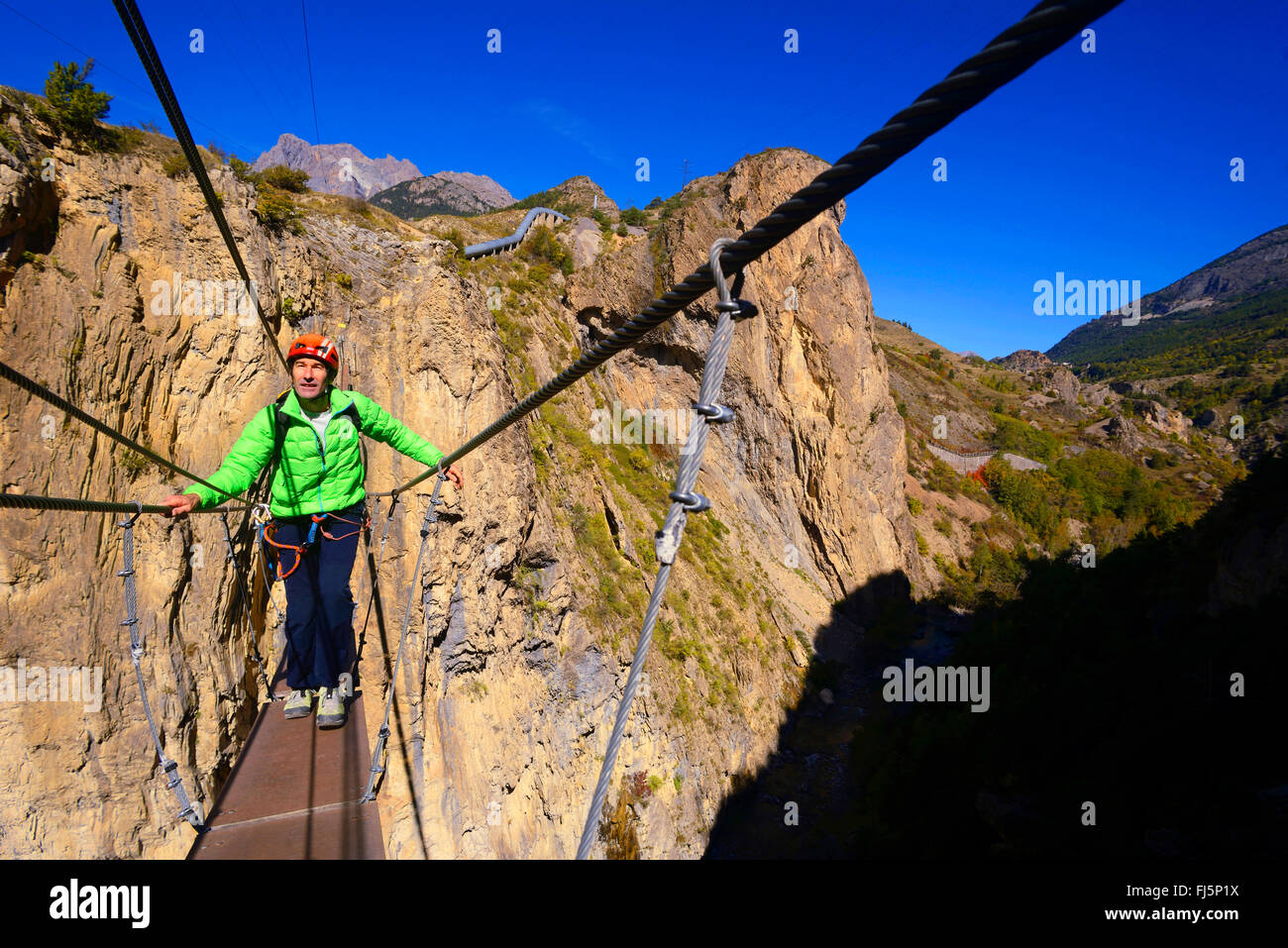 L uomo sulla sospensione ponte pedonale che attraversa il fiume Durance, Francia, Hautes Alpes Foto Stock