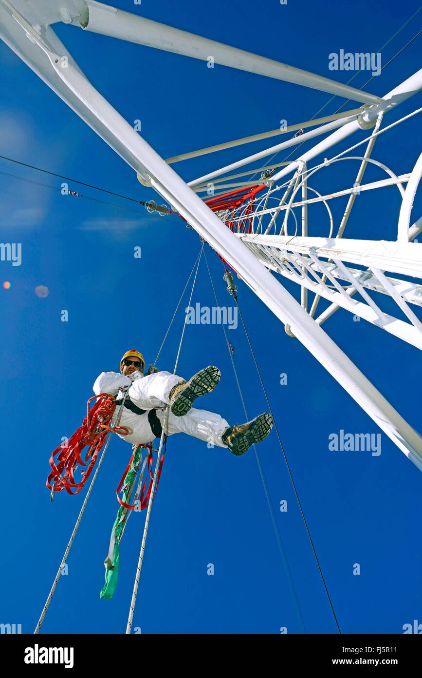 Pittore rappelling da un palo in dizzy altidude, Francia Foto Stock