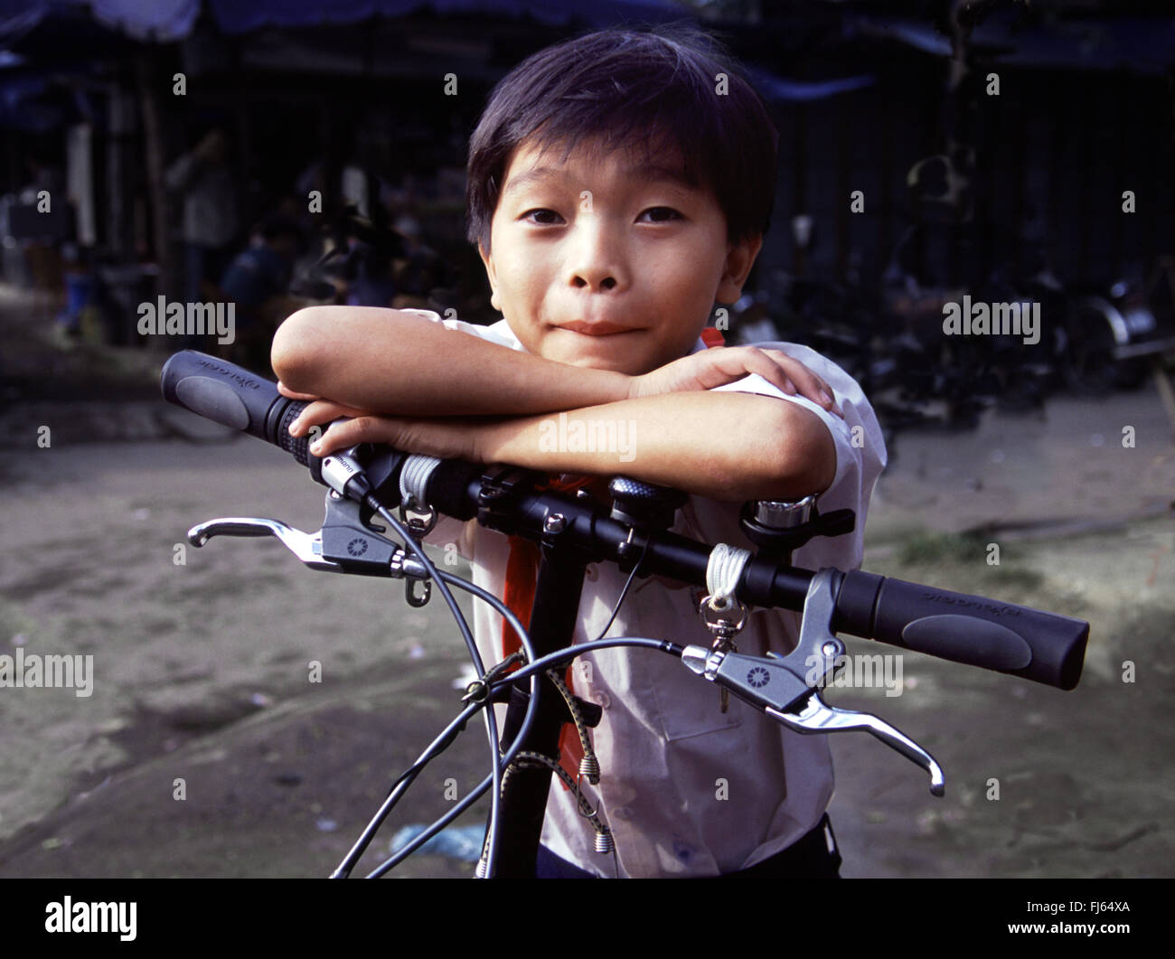 Ragazzo poggiando sulla sua bicicletta, Vietnam, Hoi An Foto Stock