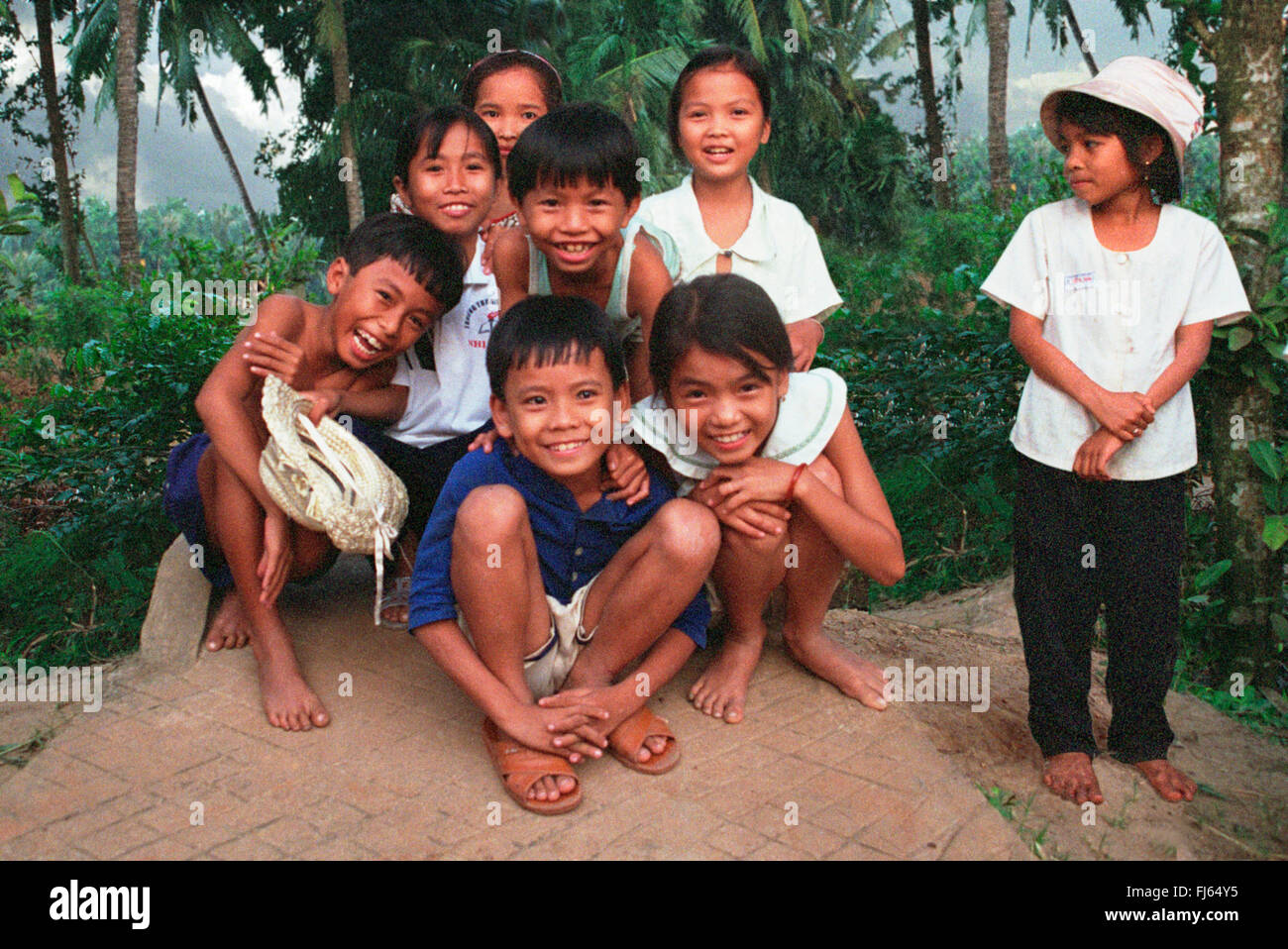 I bambini vietnamiti, accovacciato fianco a fianco, Vietnam Foto Stock