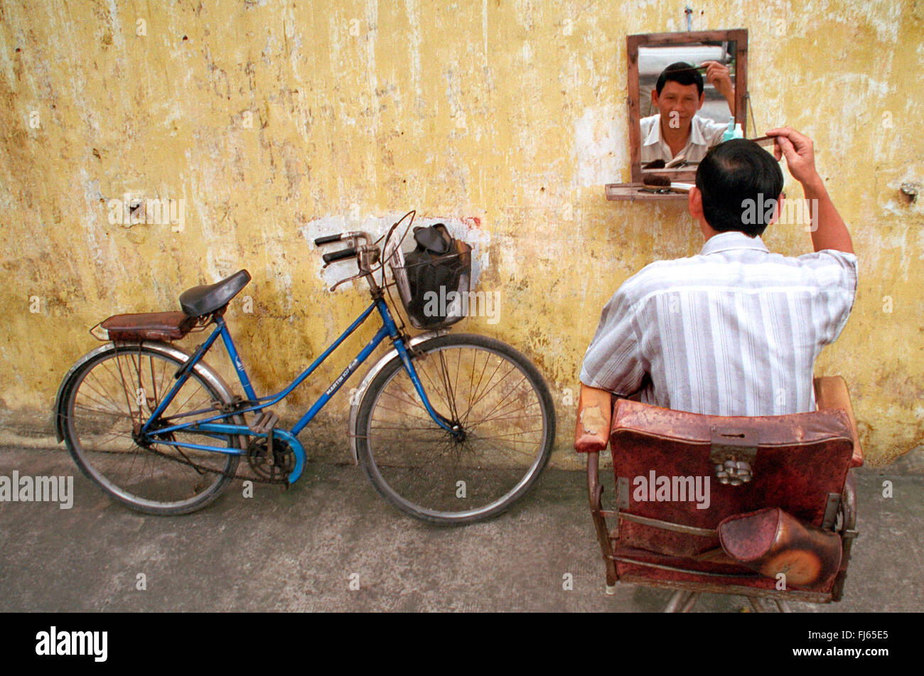 Uomo che utilizza un pettine, Vietnam Foto Stock