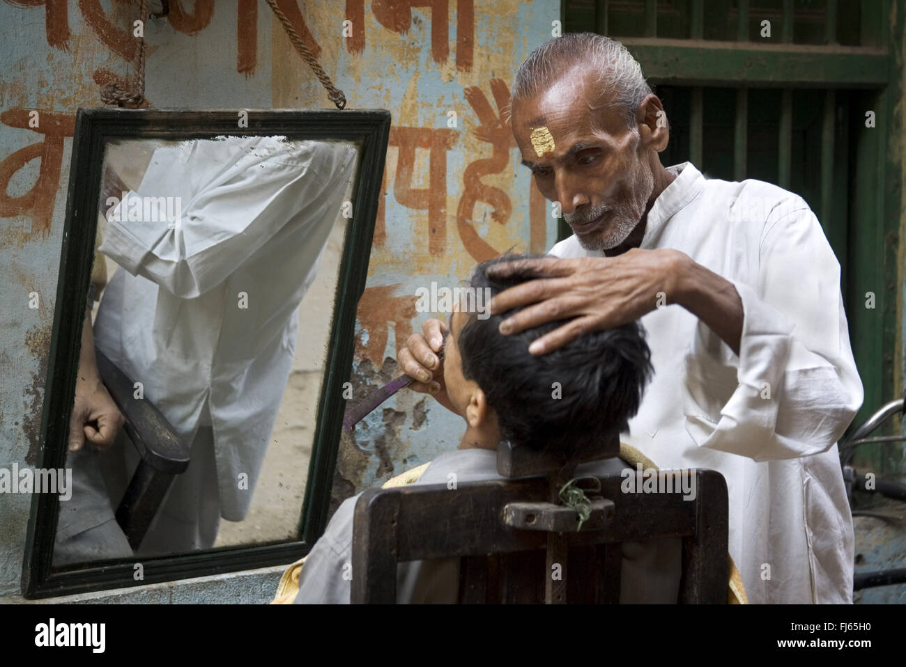 Barbiere con la clientela, India, Varanasi Foto Stock