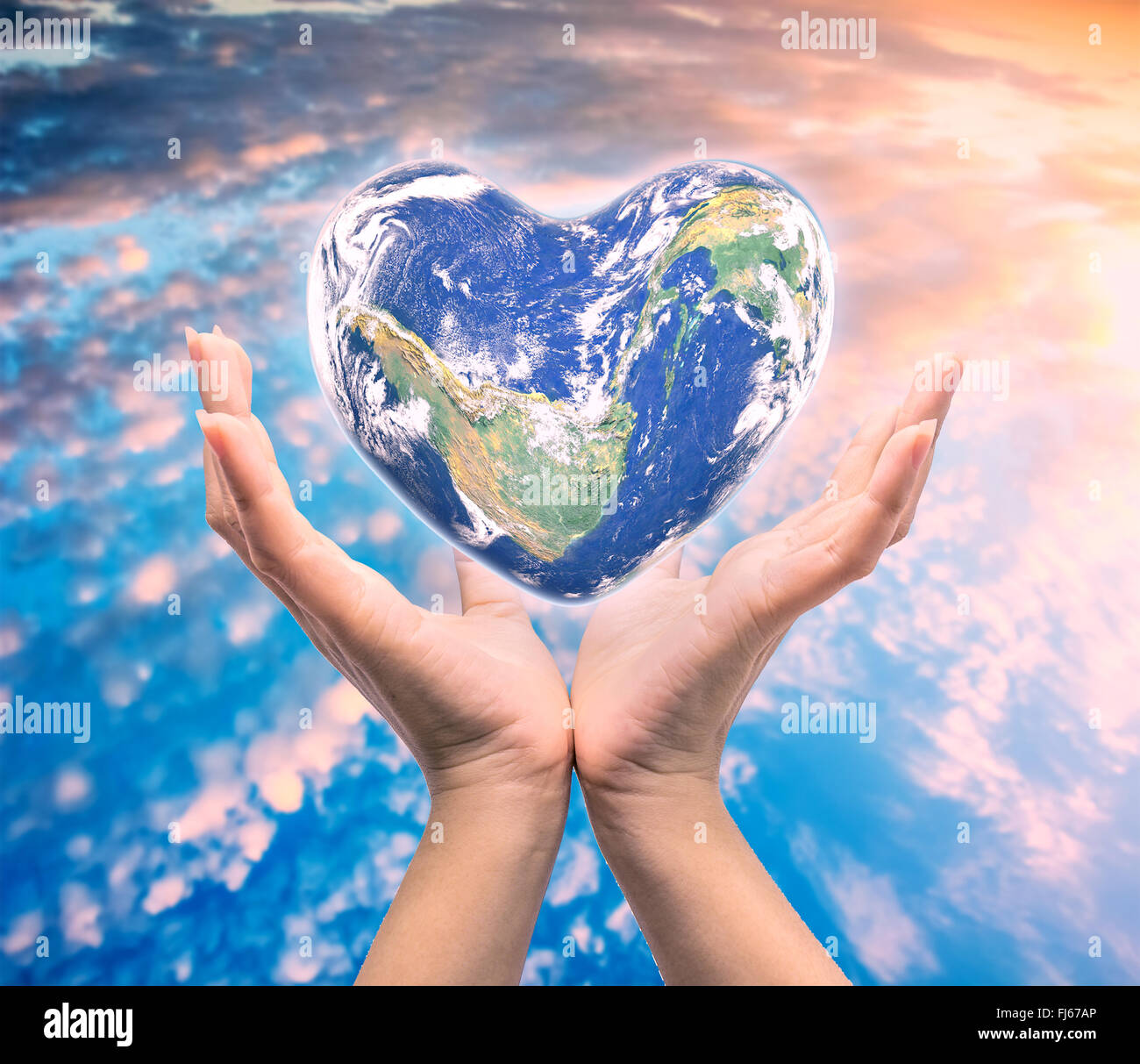 Mondo in forma di cuore con sopra le donne le mani umane su sfocato sfondo naturale: Mondo Salute del cuore giorno,Elemento di questa immagine fur Foto Stock