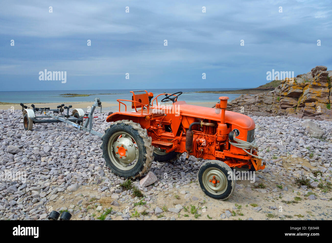 Il trattore con il rimorchio della barca sulla spiaggia di Erquy; Ilot Saint-Michel in background, Francia Bretagna, DÚpartement C¶tes-dAEArmor, Erquy Foto Stock