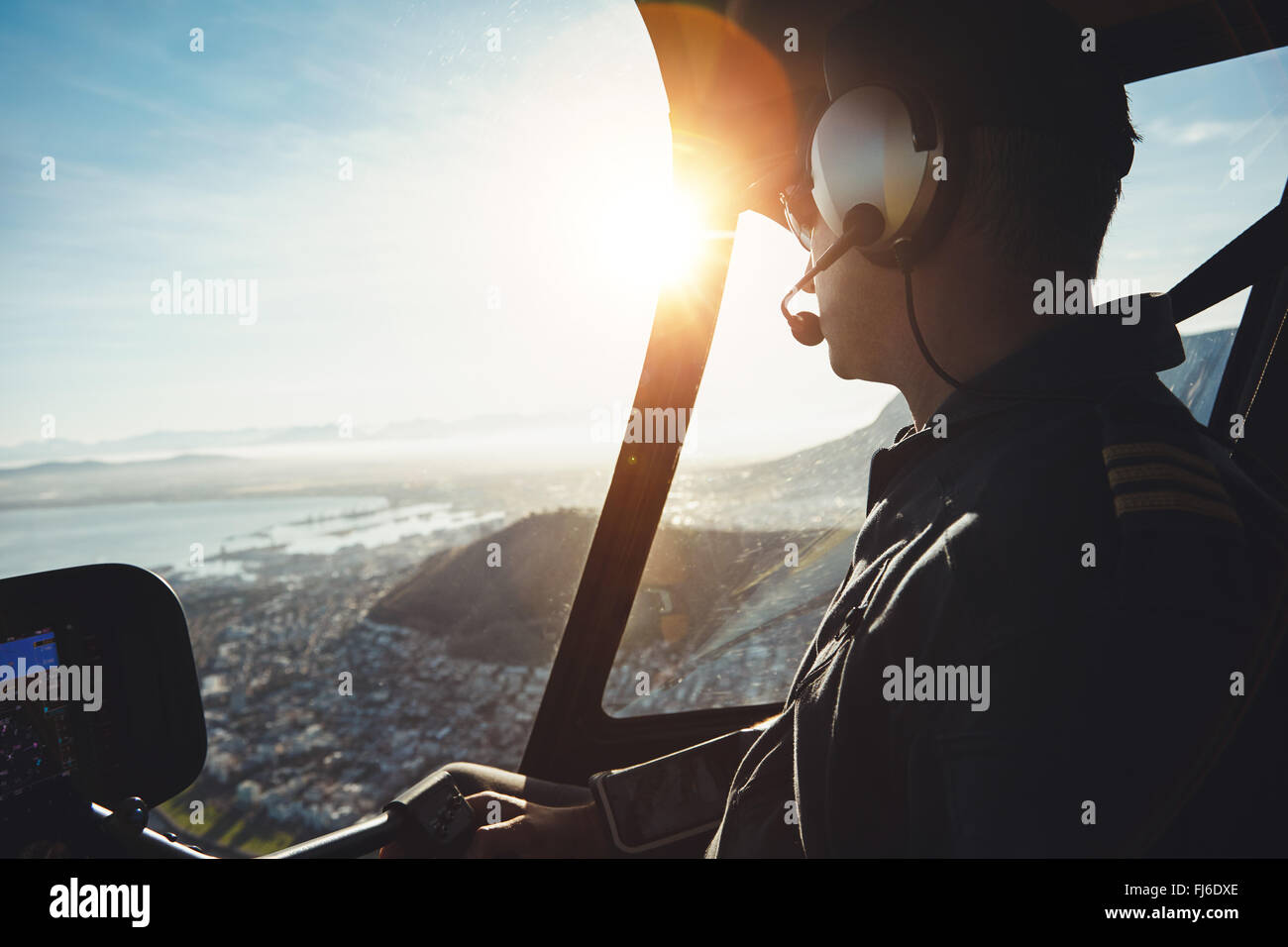 Close up di un elicottero pilota di aerei in volo su una città in una giornata di sole Foto Stock