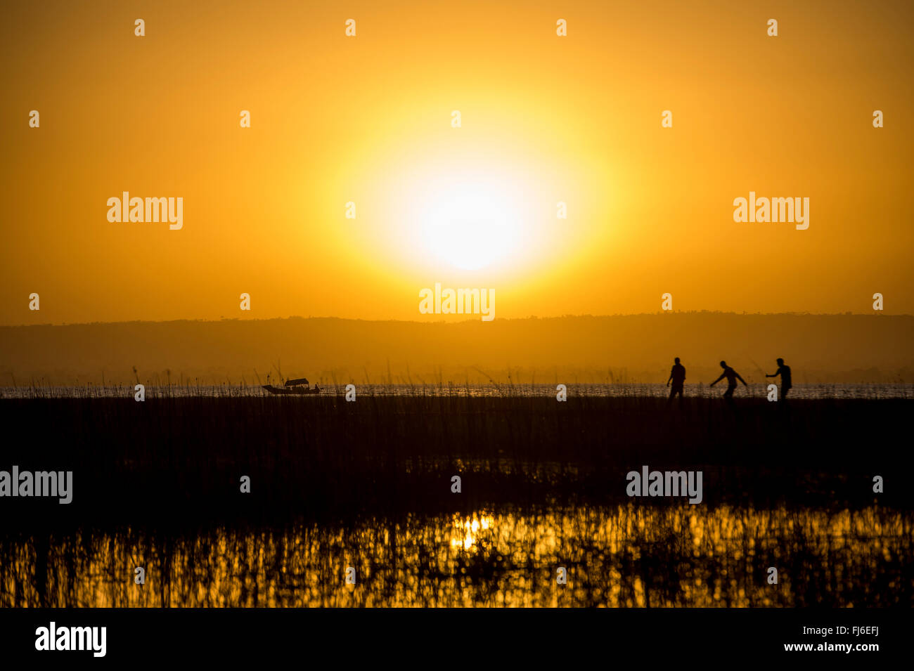 La popolazione locale a piedi sul molo al tramonto Lago Ziway, Etiopia, Africa Foto Stock