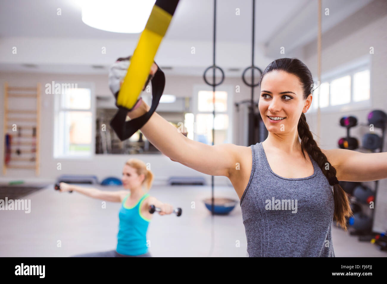 Donna in palestra di formazione con bracci di trx strisce fitness Foto Stock