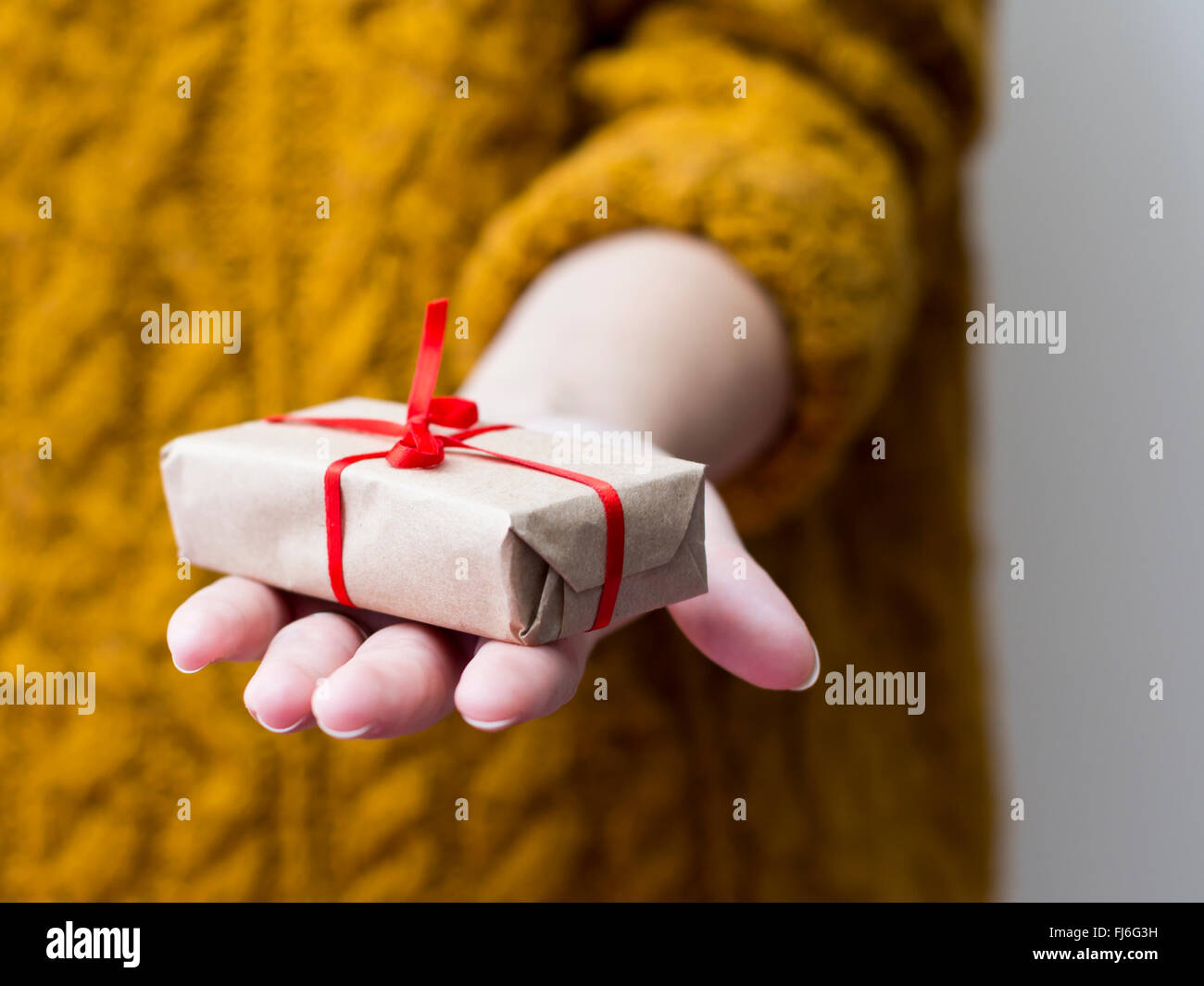 Donna di mano dando una confezione regalo Foto Stock