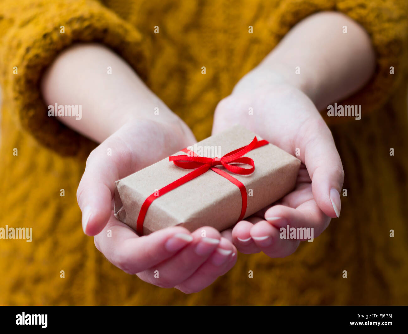 Donna di mano dando una confezione regalo Foto Stock