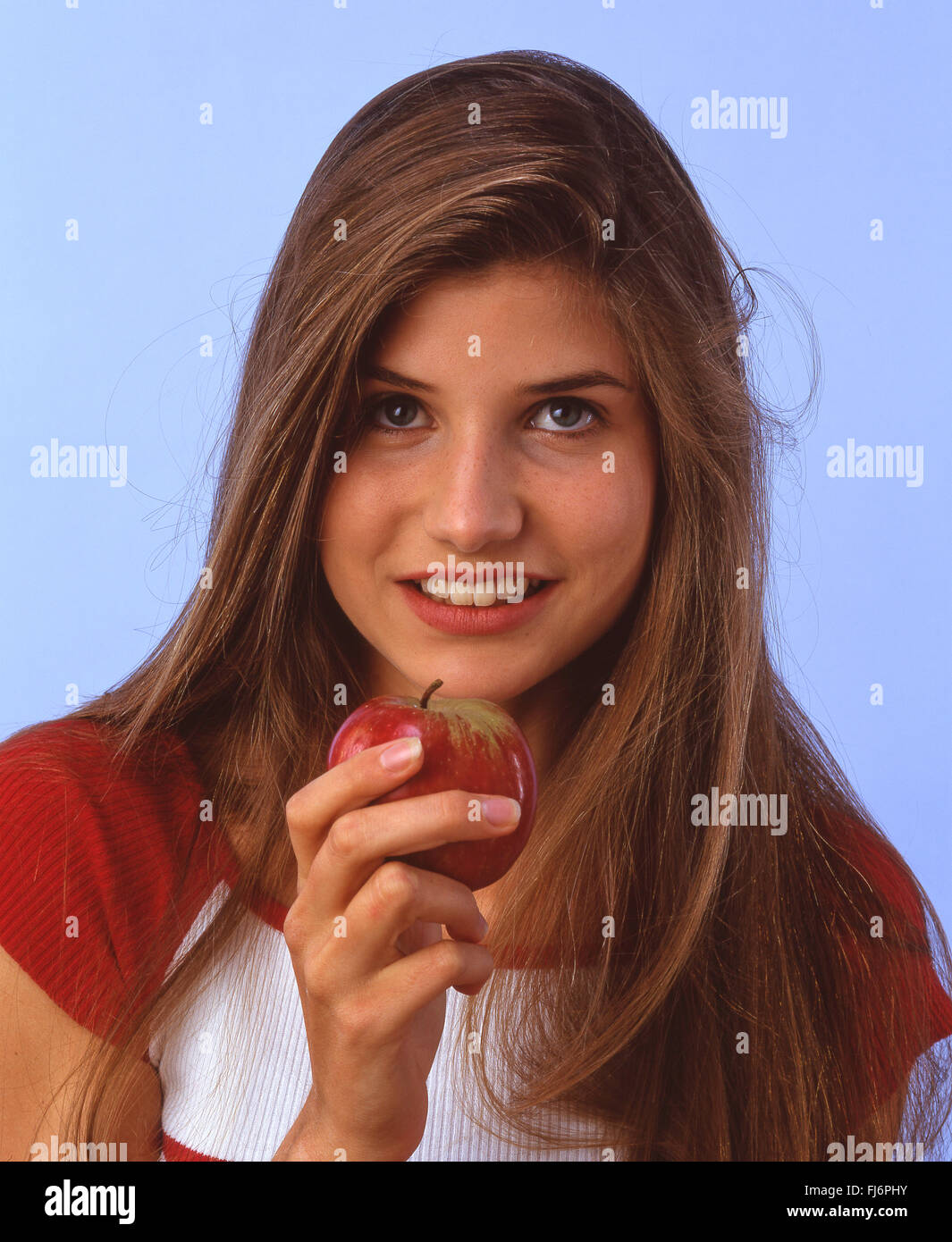 Giovane donna azienda apple, London, England, Regno Unito Foto Stock