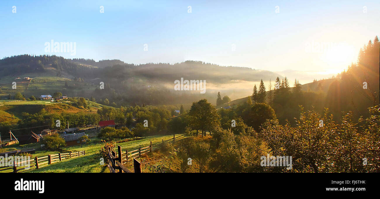 Sun sollevare il villaggio di montagna paesaggio Foto Stock