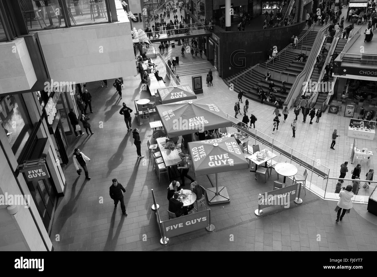 Cinque ragazzi di posti a sedere esterni anf area pranzo all'interno della Cabot Circus mall in Bristol, 27 Febbraio 2016 Foto Stock