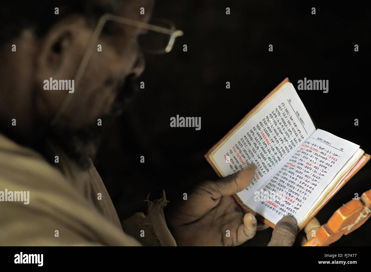 Sacerdote ortodosso letture sacre Scritture all'interno di Mikael Milhaizengi rupestri chiesa nel Tigray, Etiopia Foto Stock