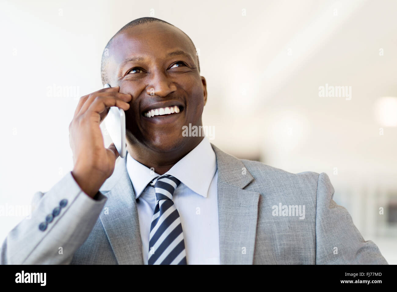 Allegro imprenditore nero parlando su smart phone in office Foto Stock