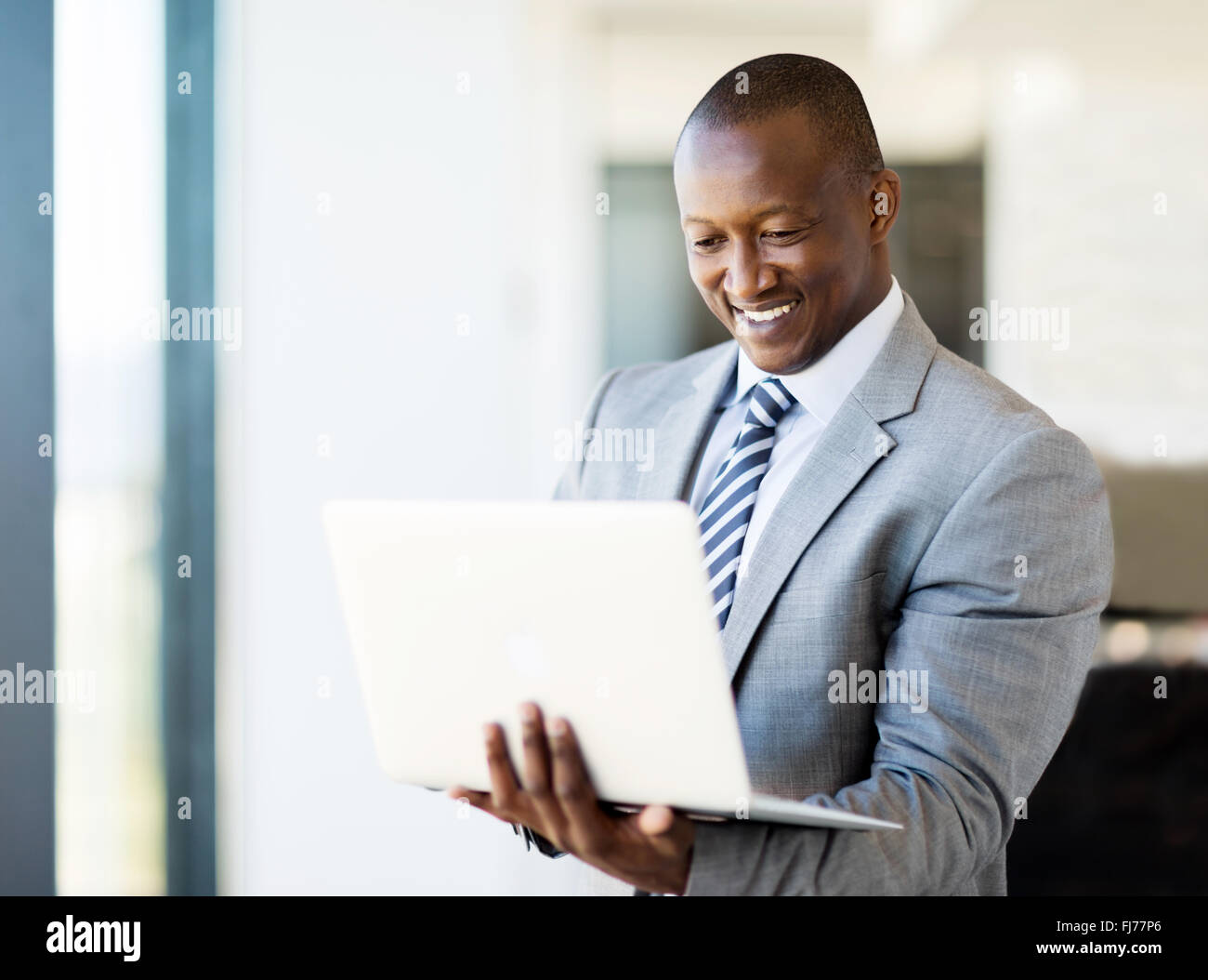 Smart African uomo d affari con computer portatile in ufficio Foto Stock