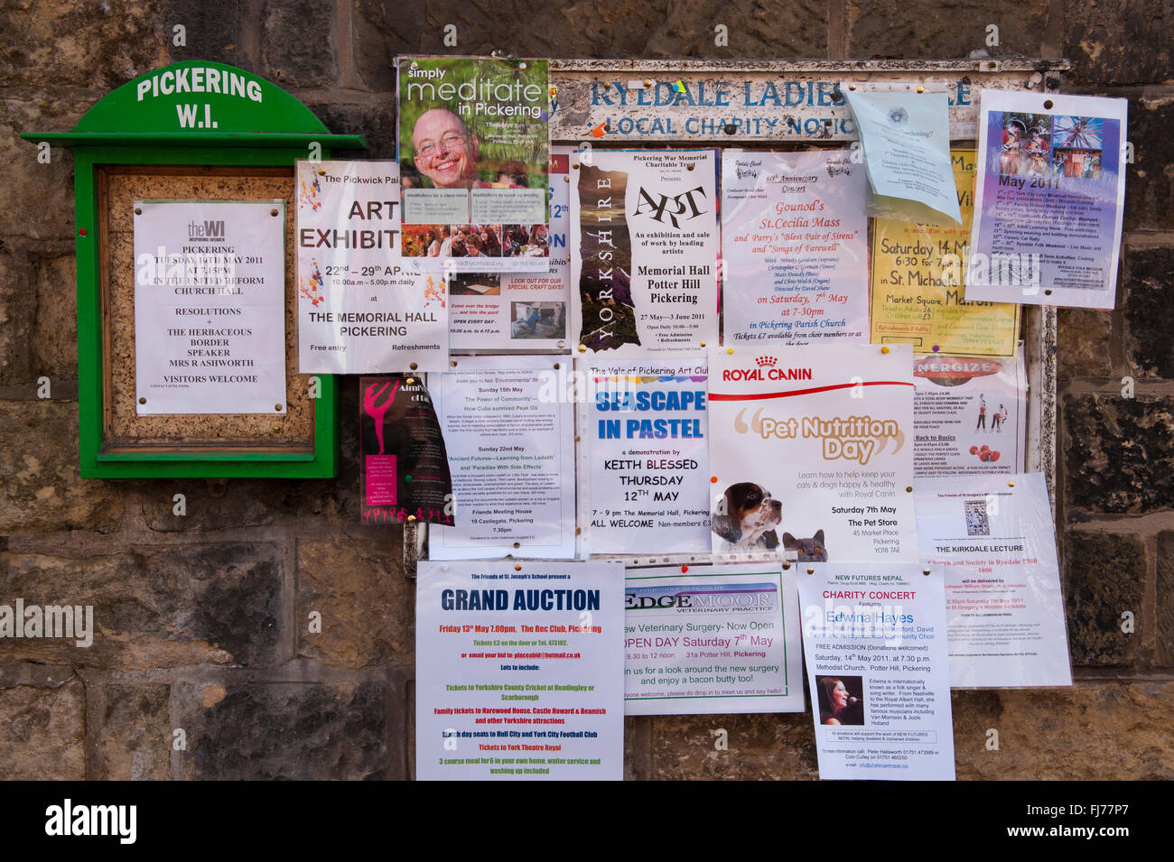 A cosa? - Close-up di avvisi (carta) imperniata al WI e comunità locale bacheca in centro città, Pickering, North Yorkshire, Inghilterra. Foto Stock