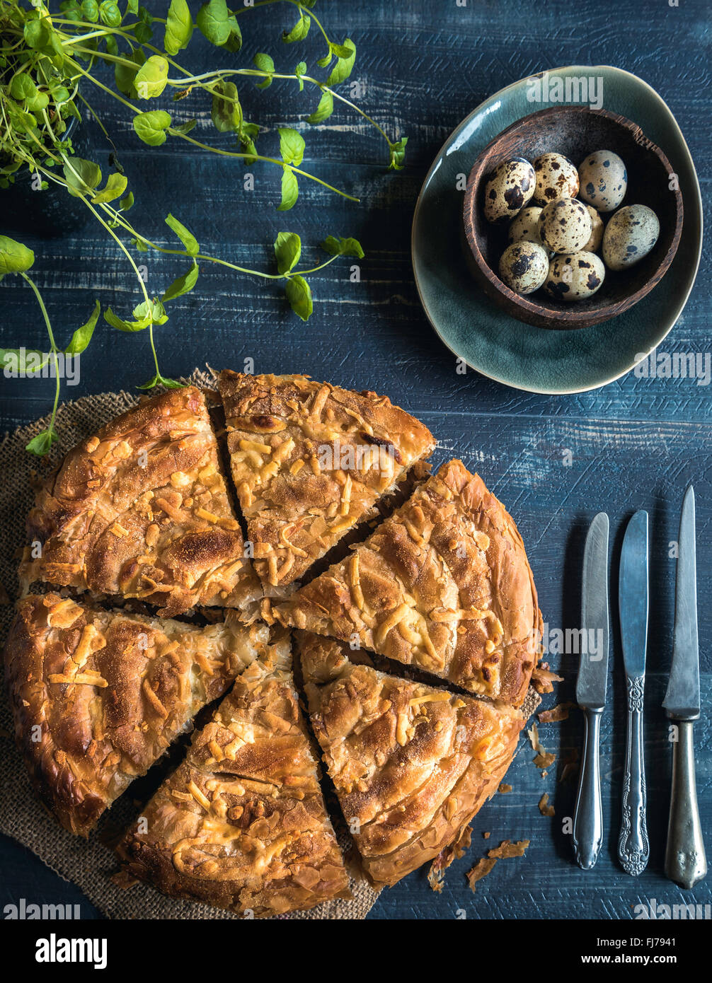 In casa e doppio a fette di torta di formaggio e uova di quaglia su sfondo di legno,cucina di Pasqua Foto Stock