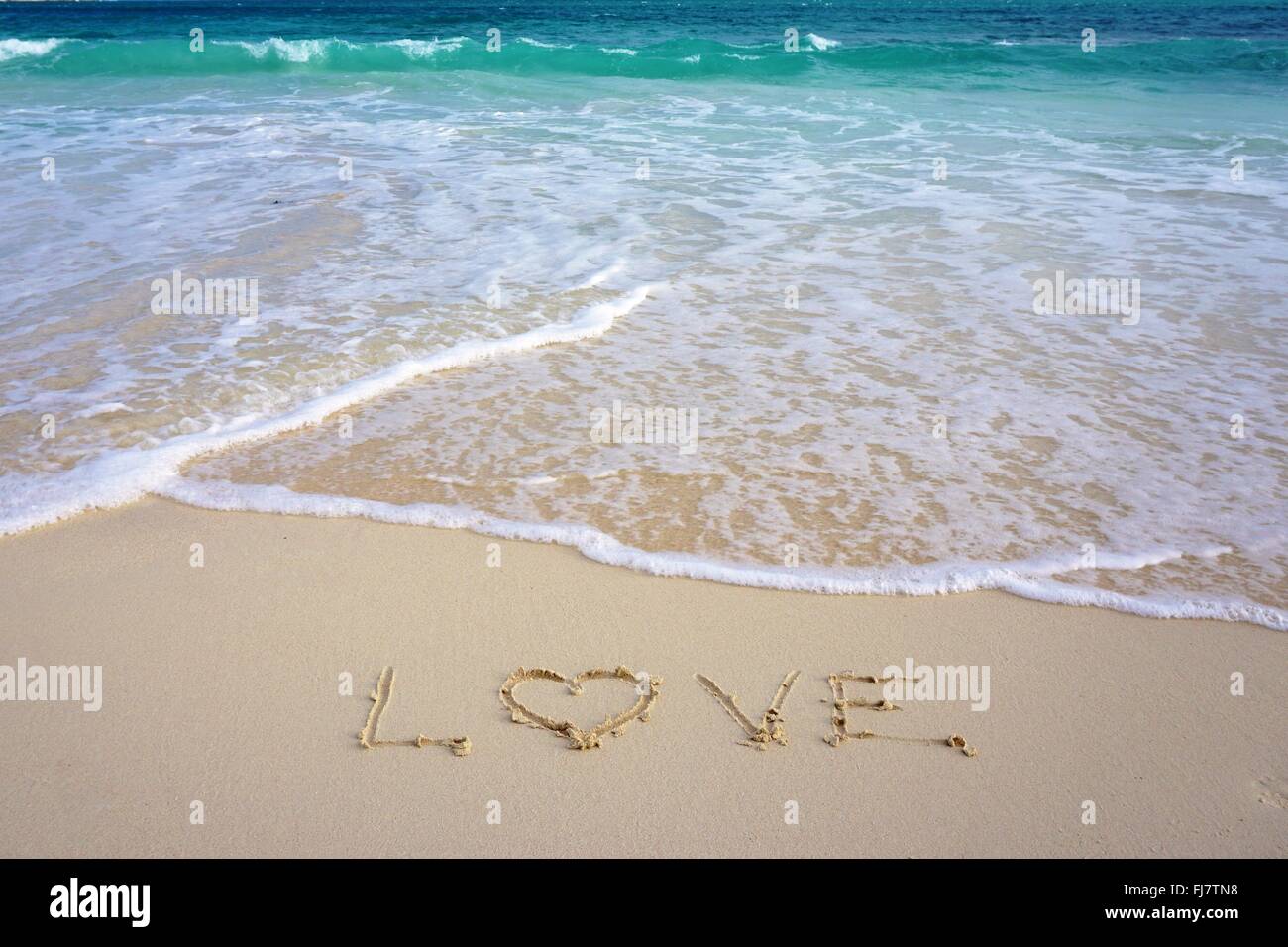 "L'amore" scritto nella sabbia sulla spiaggia Foto Stock