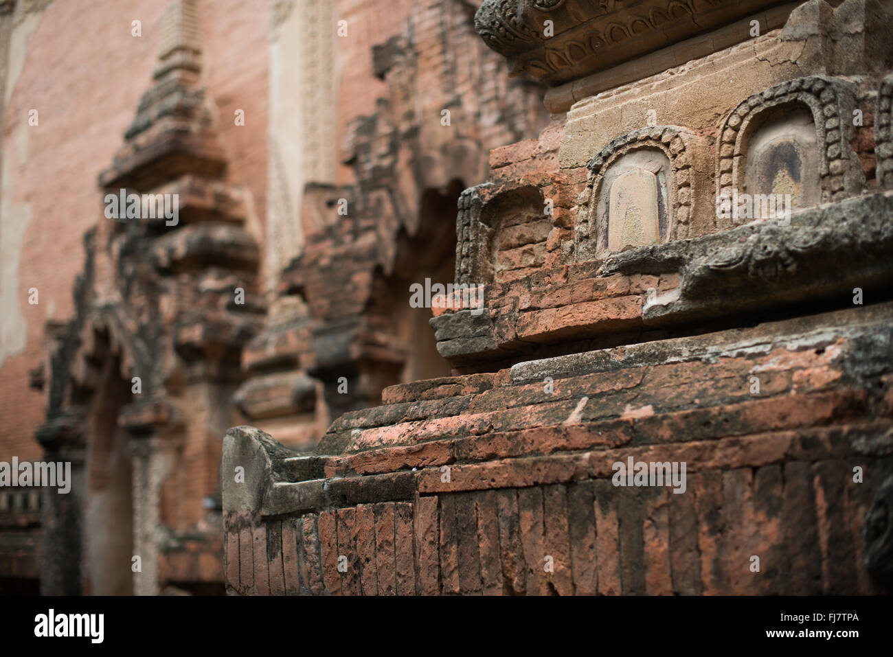 Elementi decorativi del Tempio di Htilominlo Bagan Myanmar // BAGAN, Myanmar — l'esterno del Tempio di Htilominlo mostra sia elementi decorativi originali del XIII secolo che moderni lavori di restauro. Questo tempio buddista fu costruito durante il regno di re Htilominlo (1211-1235) e mostra lo stile architettonico della dinastia pagana. Il tempio sorge tra le migliaia di monumenti religiosi che punteggiano la zona archeologica di Bagan, un sito patrimonio dell'umanità dell'UNESCO. Il tempio di Htilominlo è noto per le sue decorazioni in stucco ben conservate e le placche in pietra arenaria smaltata. La struttura rappresenta il conser in corso Foto Stock