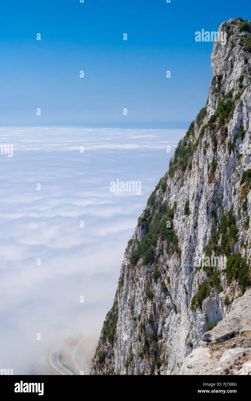 Gibilterra scogliera sopra le nuvole con la strada sotto contro il cielo blu e chiaro. Foto Stock