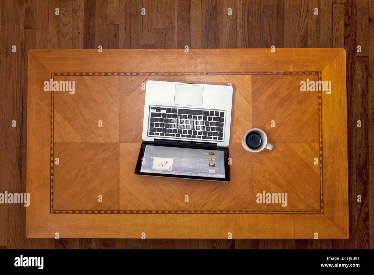 Guardando verso il basso su un art deco table top con un computer portatile ed una tazza di caffè. Foto Stock