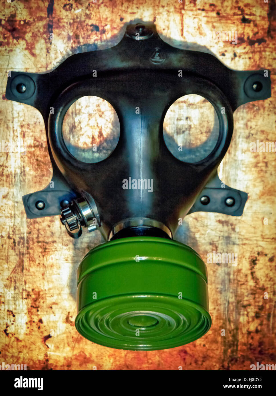 Una maschera a gas seduto su un sfondo arrugginito Foto Stock