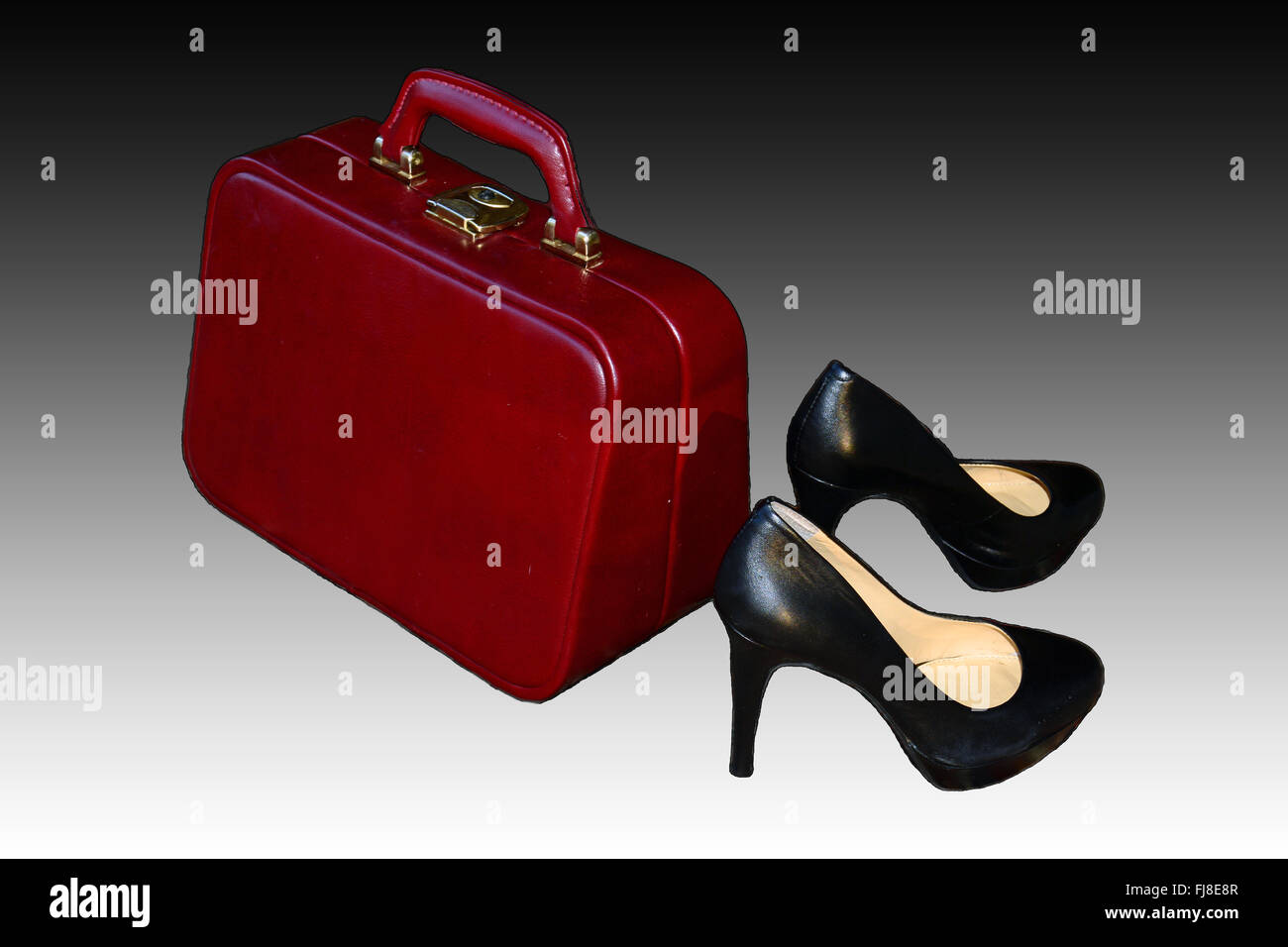 Valigia di ciliegia e un paio di scarpe nere,gradiente nero e sfondo bianco Foto Stock
