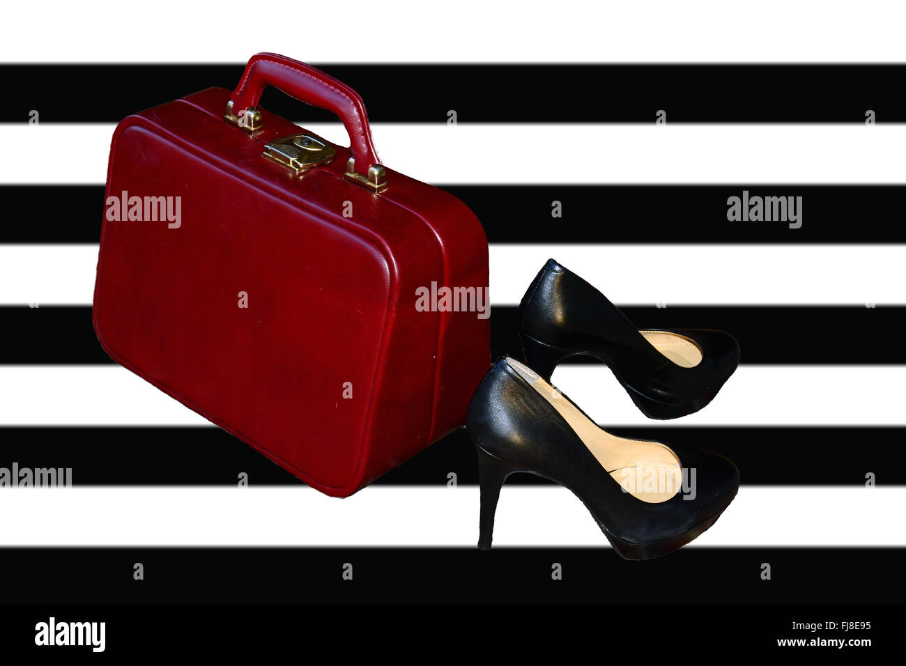 Il bagaglio a mano e scarpe. Red valigia, tacchi alti sfondo Foto Stock