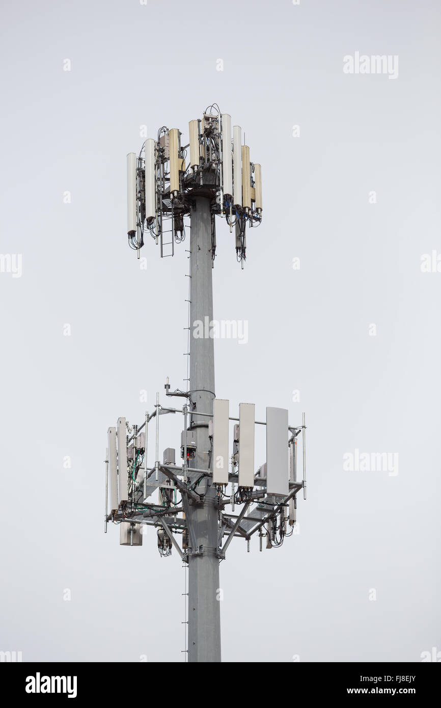 Telefono cellulare e la ricezione di dati fino a torre alto nel cielo. Foto Stock