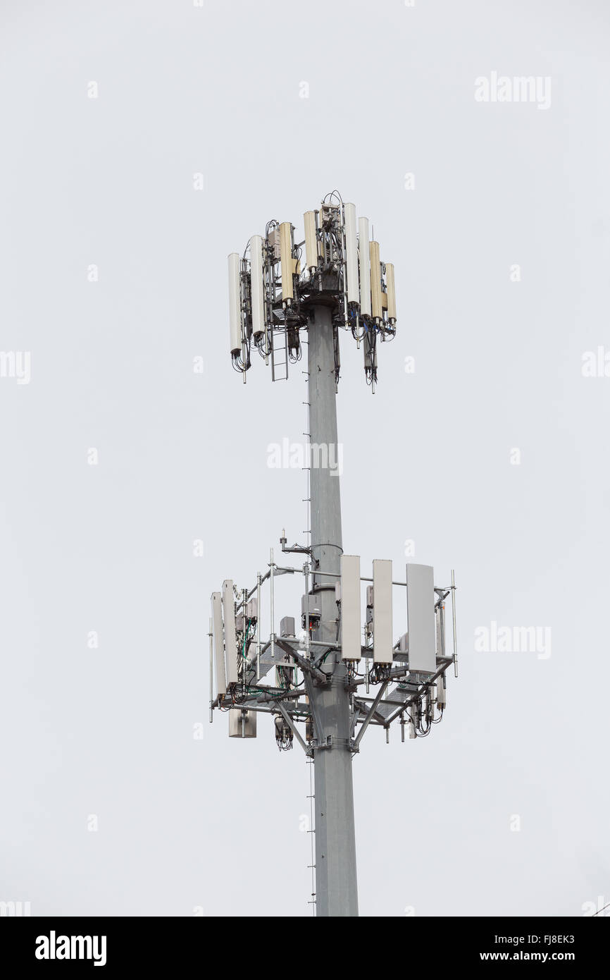 Telefono cellulare e la ricezione di dati fino a torre alto nel cielo. Foto Stock