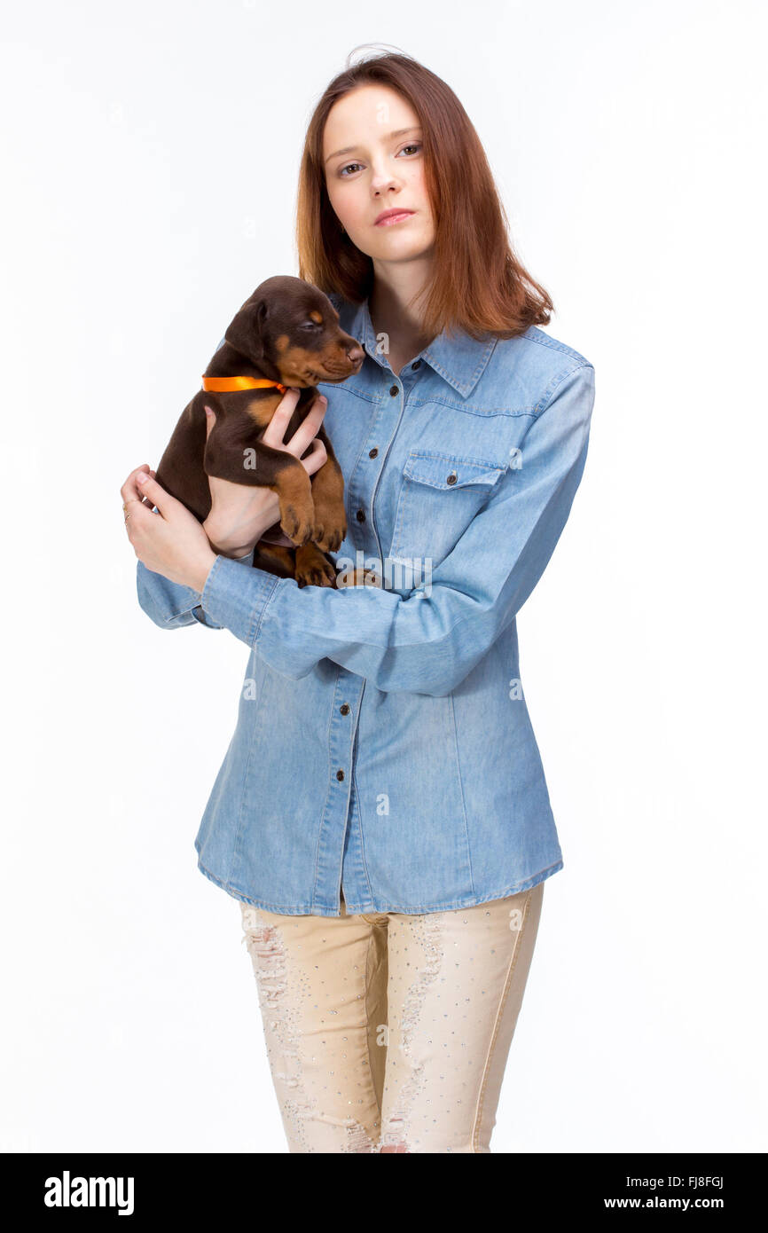 Bella donna detiene red doberman cucciolo di cane sulle sue mani, isolato su bianco Foto Stock