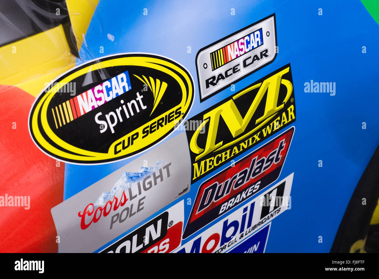 Il lato destro di un NASCAR Racecar che mostra le decalcomanie Sponsor disposte in filari dietro il pneumatico anteriore destro Foto Stock