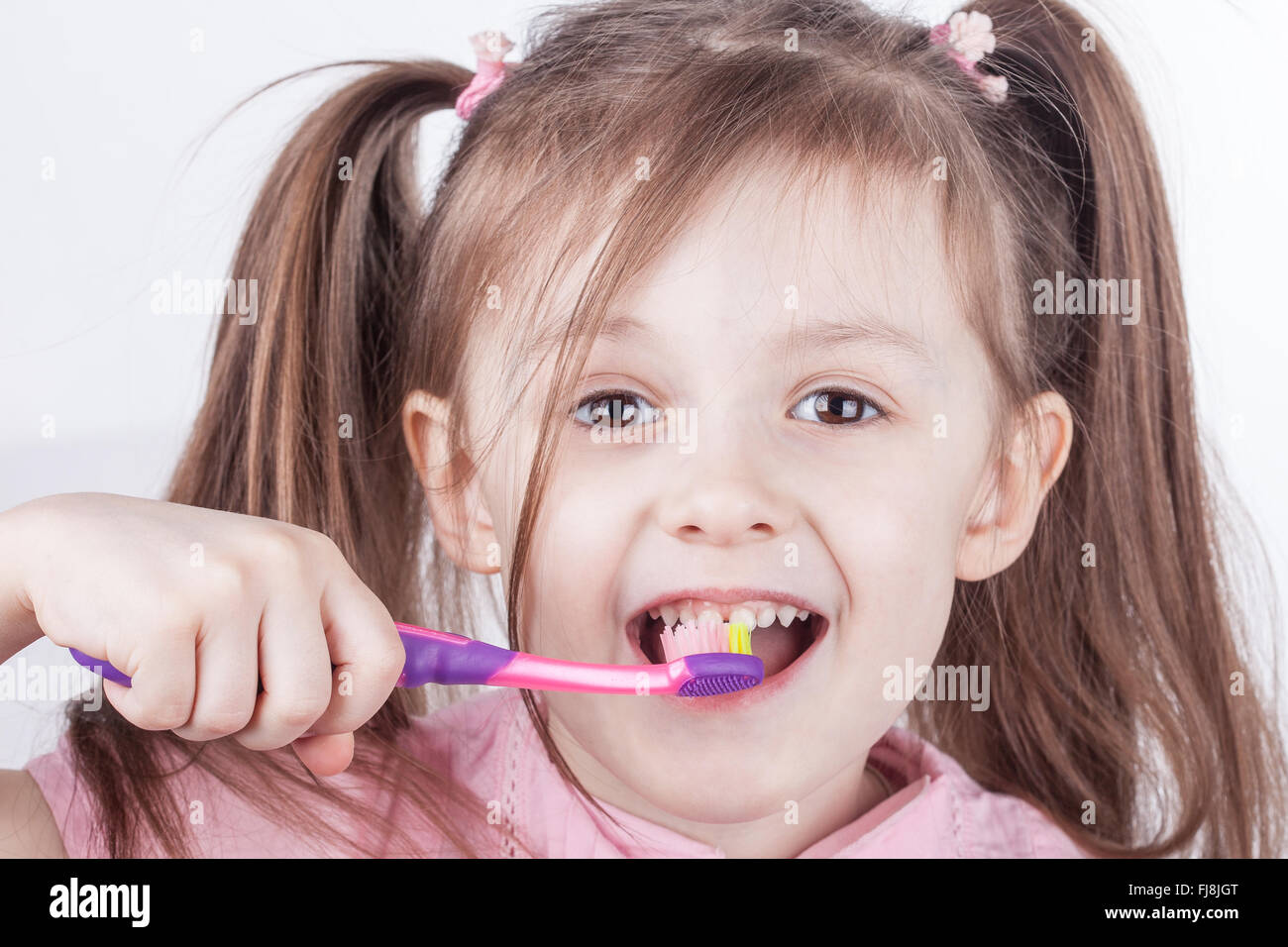 Igiene dentale. Felice bambina spazzolare i suoi denti. isolato Foto Stock