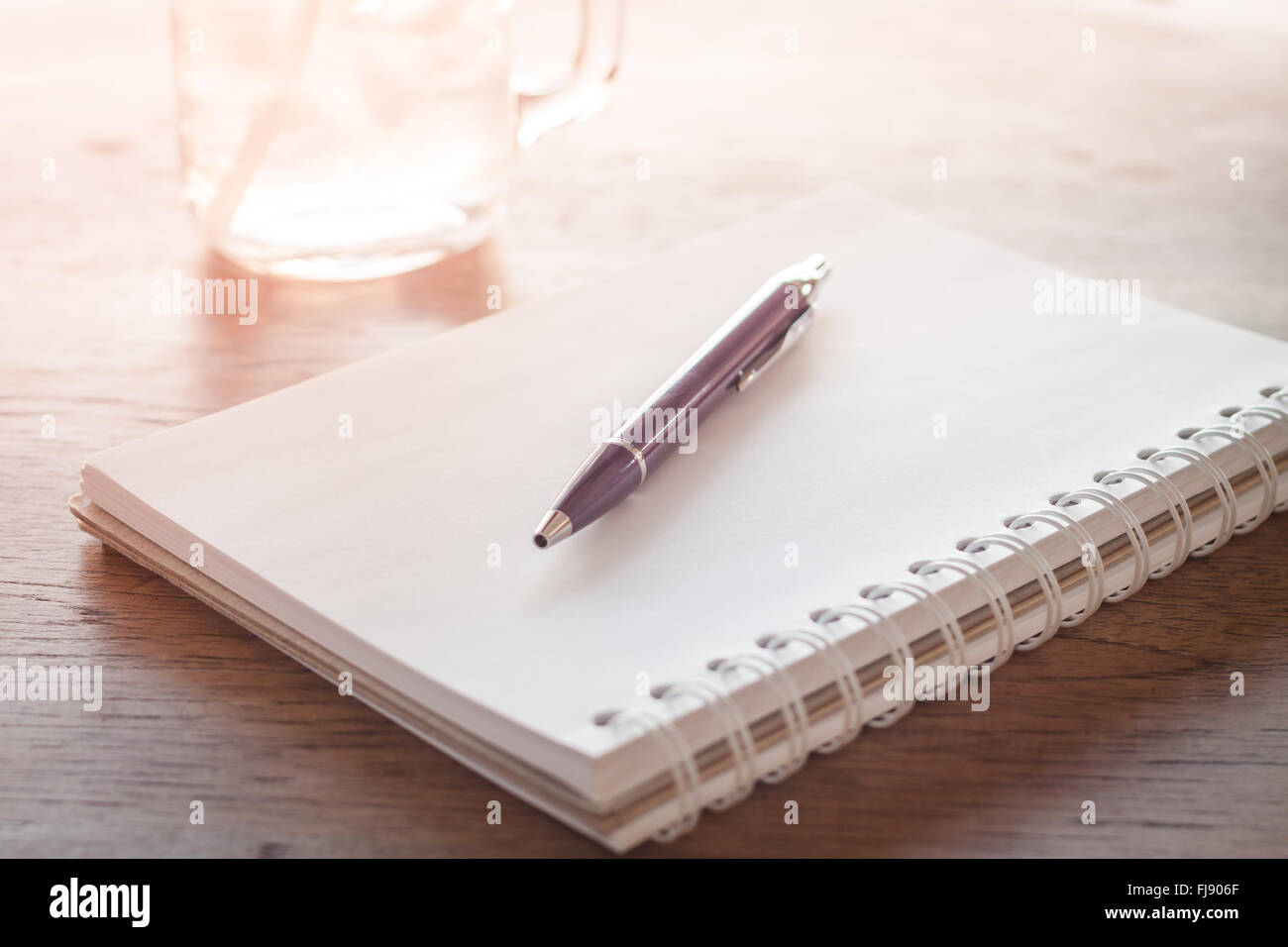 Stazione di lavoro con notebook e penna con filtro vintage Foto Stock