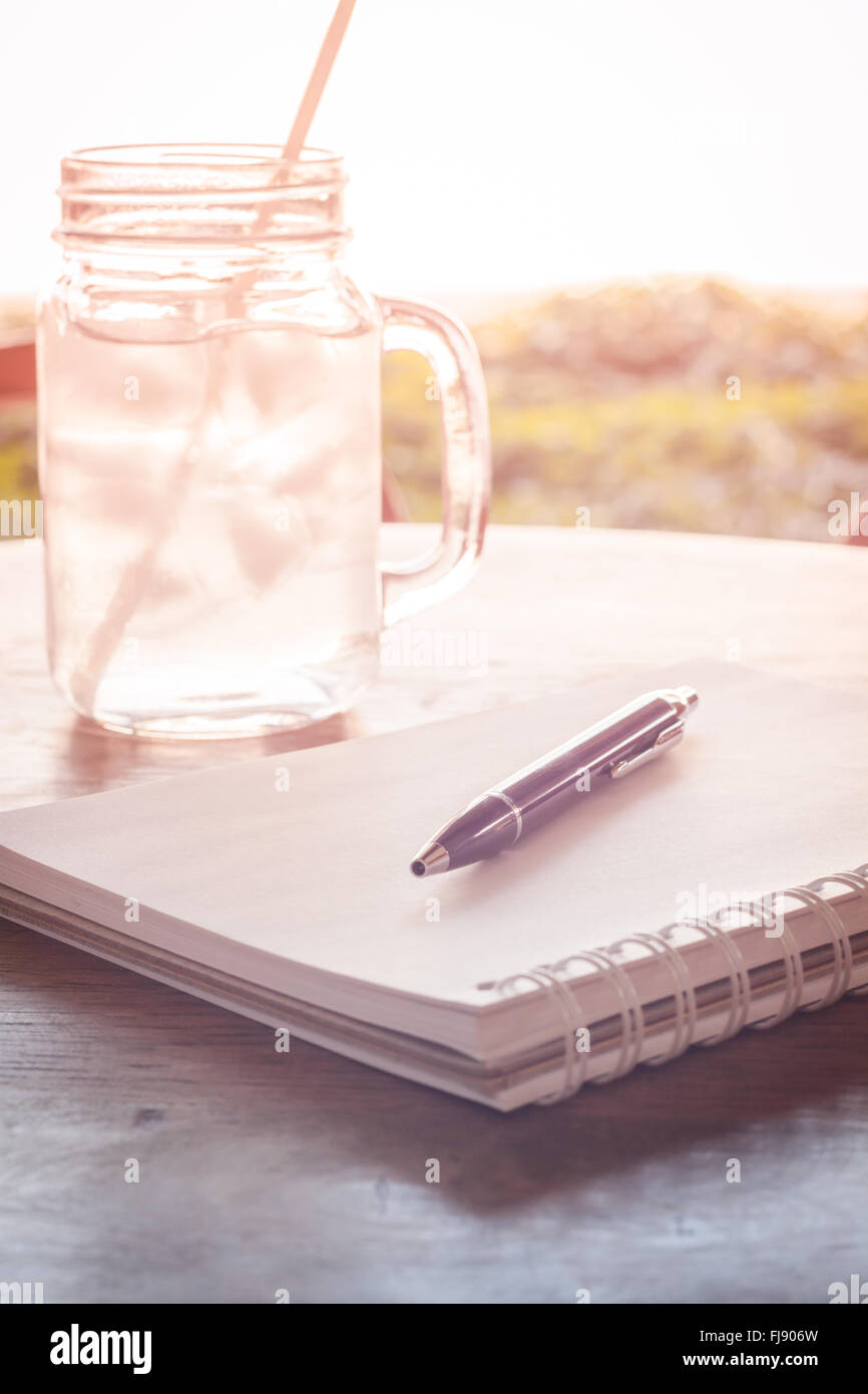 Stazione di lavoro con notebook e penna con filtro vintage Foto Stock