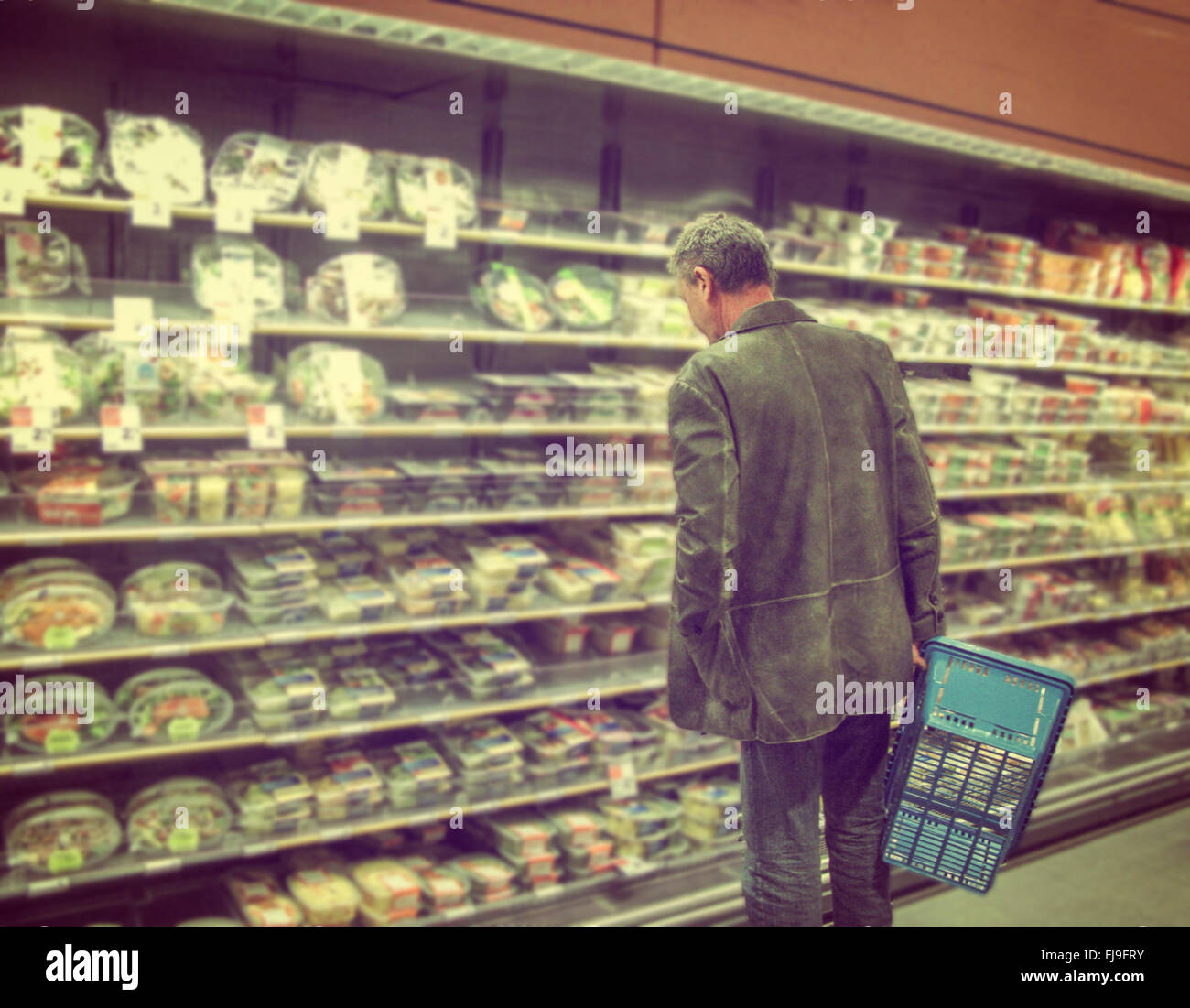 Uomo con carrello scegliendo il cibo nel supermercato Foto Stock