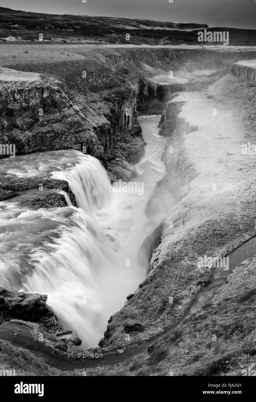 Guardando verso il basso la gola Hvítá a Gullfoss. Spruzzare da una cascata ha congelato sul prato circostante e rocce Foto Stock
