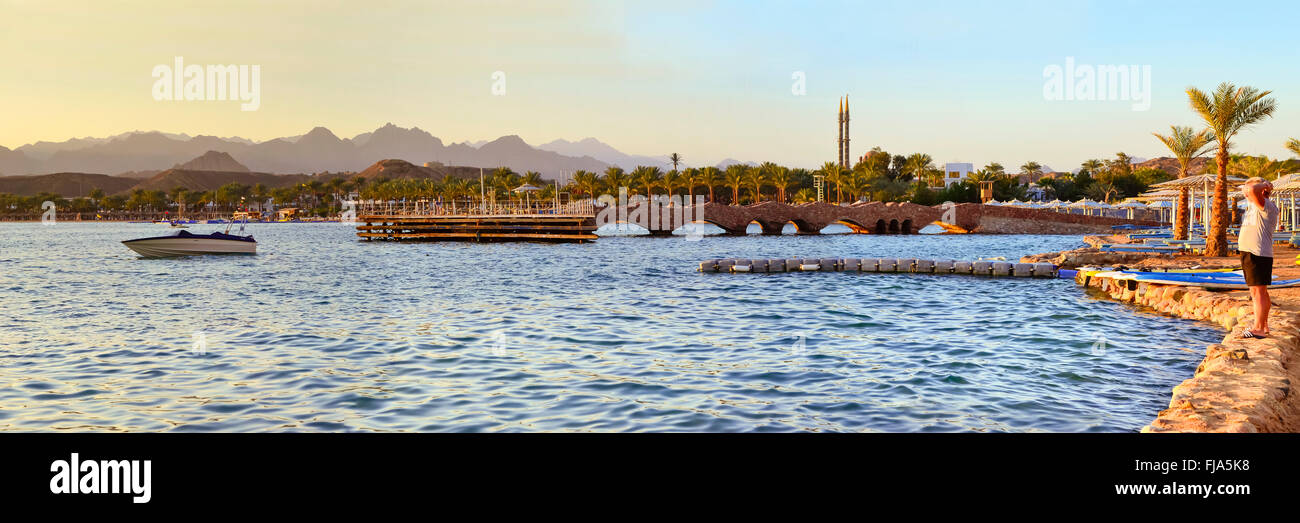 SHARM EL SHEIKH, Egitto - 28 febbraio 2014: barca nei pressi di un molo in legno sulla spiaggia la sera, la costa del mar rosso da hotel beach Foto Stock
