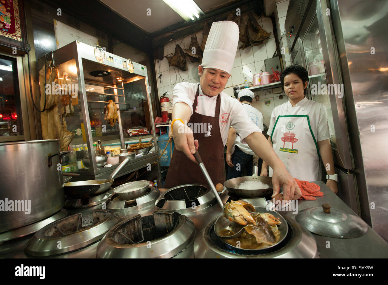 Cuoco cinese usando un wok a Chinatown, Bangkok Foto Stock